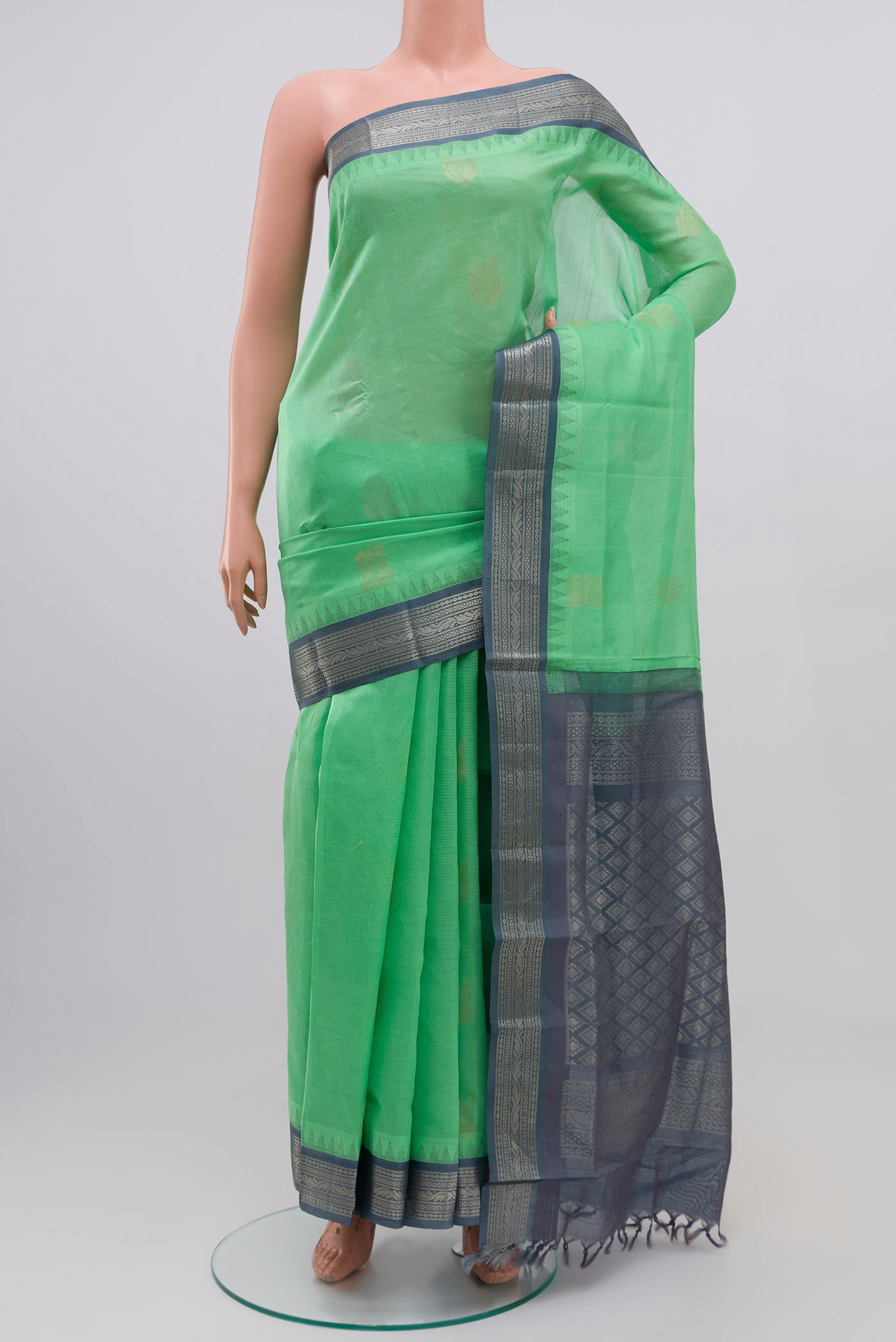 Green Silk Cotton Saree with Zari Butta on the body and Zari Border.  displayed on a mannequin