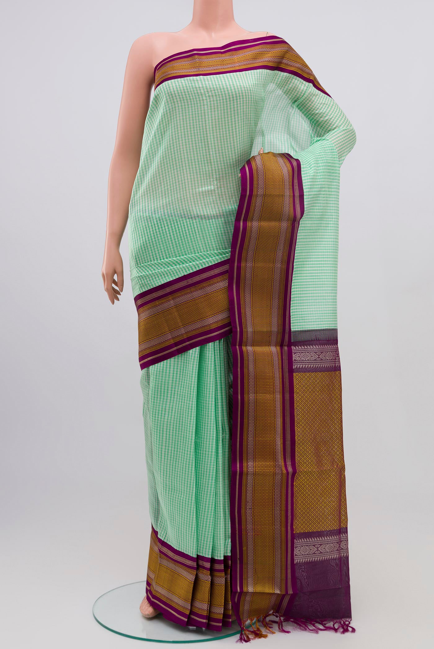 Green Silk Cotton Saree with Checked design on the body and Thread Border.  displayed on a mannequin