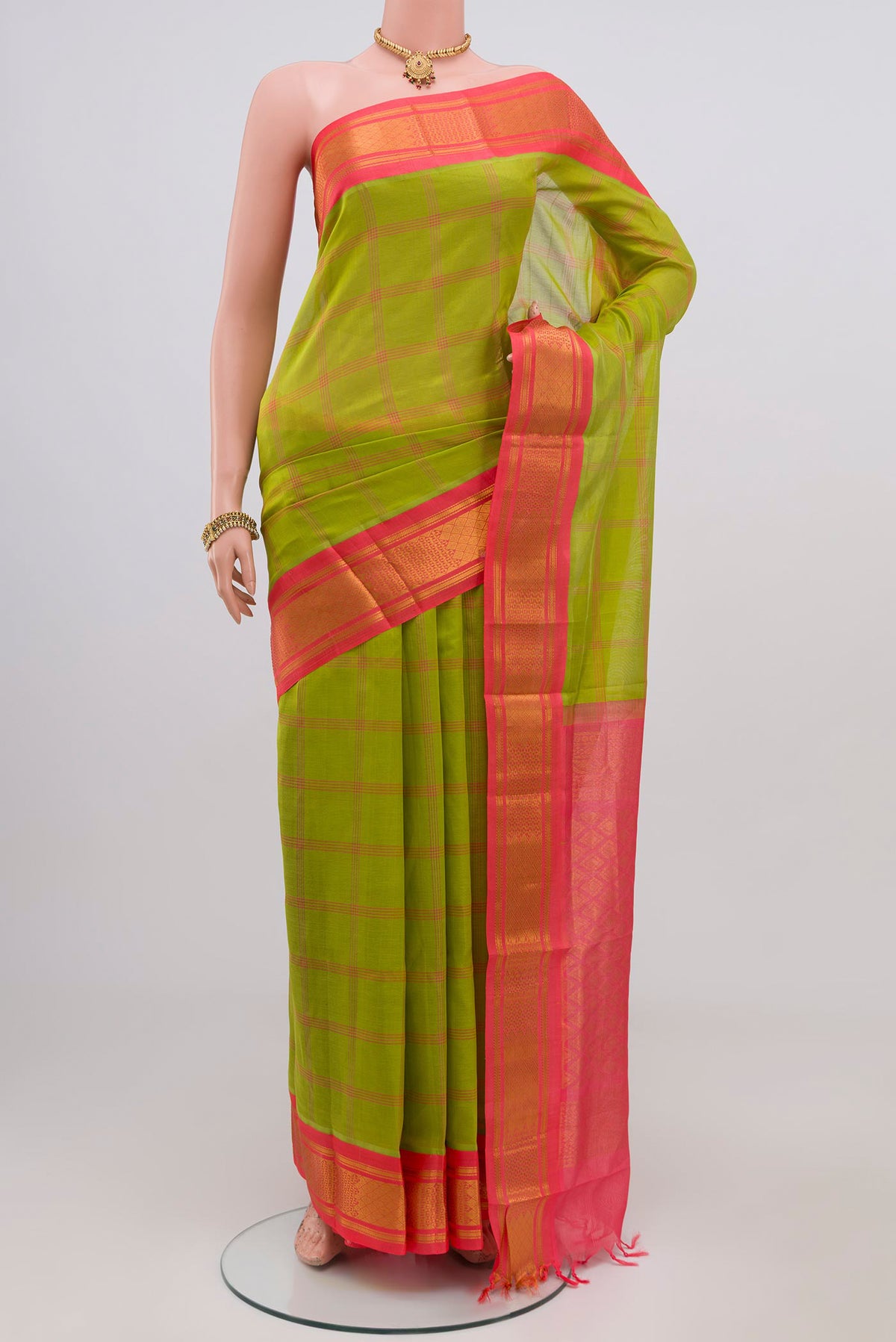 Green Silk Cotton Saree with Checked design on the body and Zari Border.  displayed on a mannequin