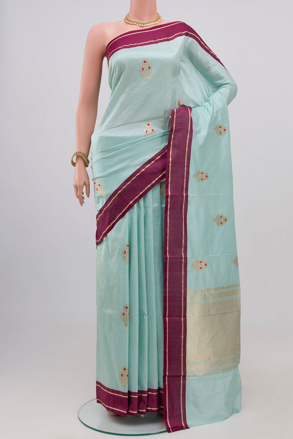 Light Blue Banarasi Katan Silk Saree with Zari Butta on the body and Plain Border.  displayed on a mannequin