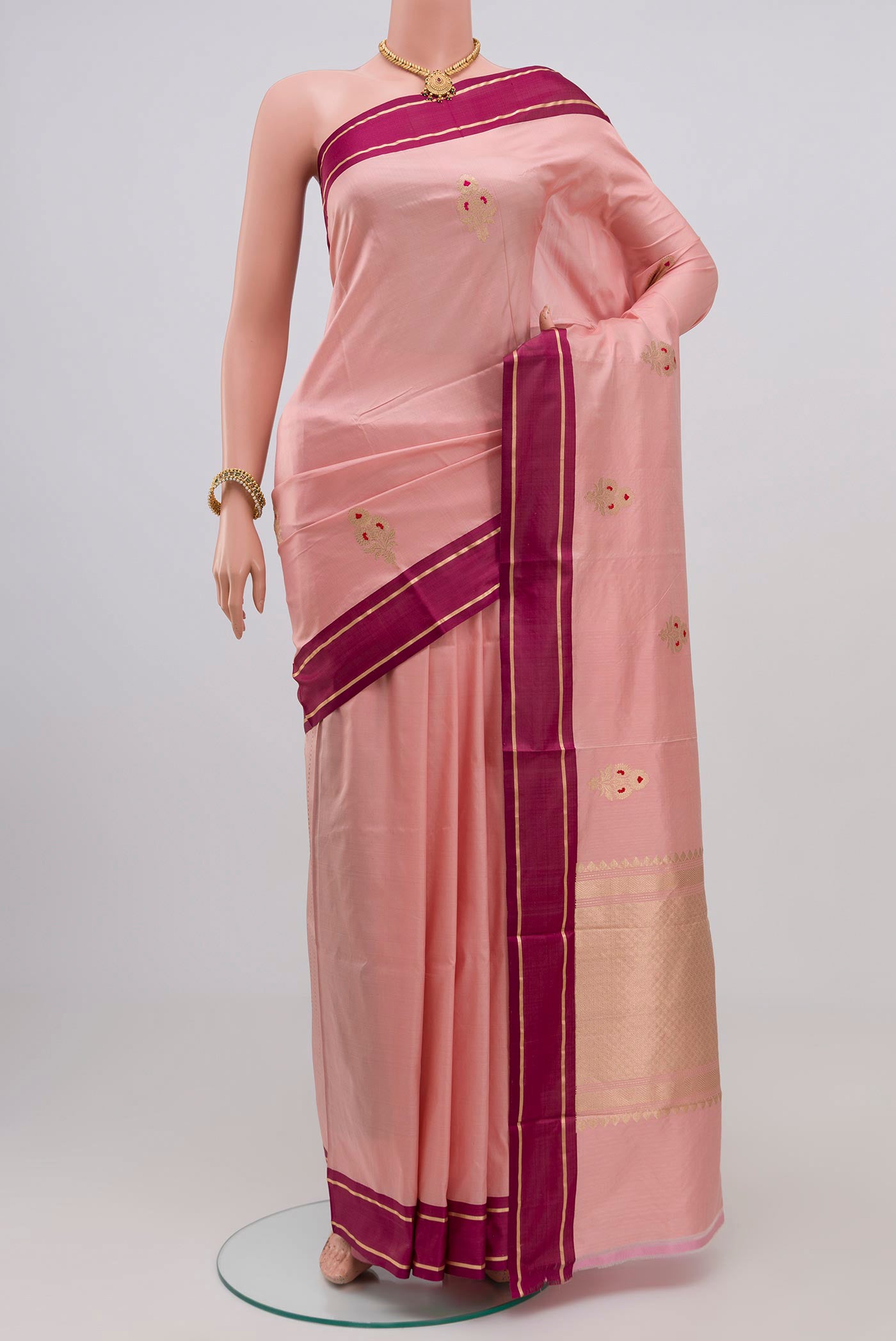 Pink Banarasi Katan Silk Saree with Zari Butta on the body and Plain Border.  displayed on a mannequin