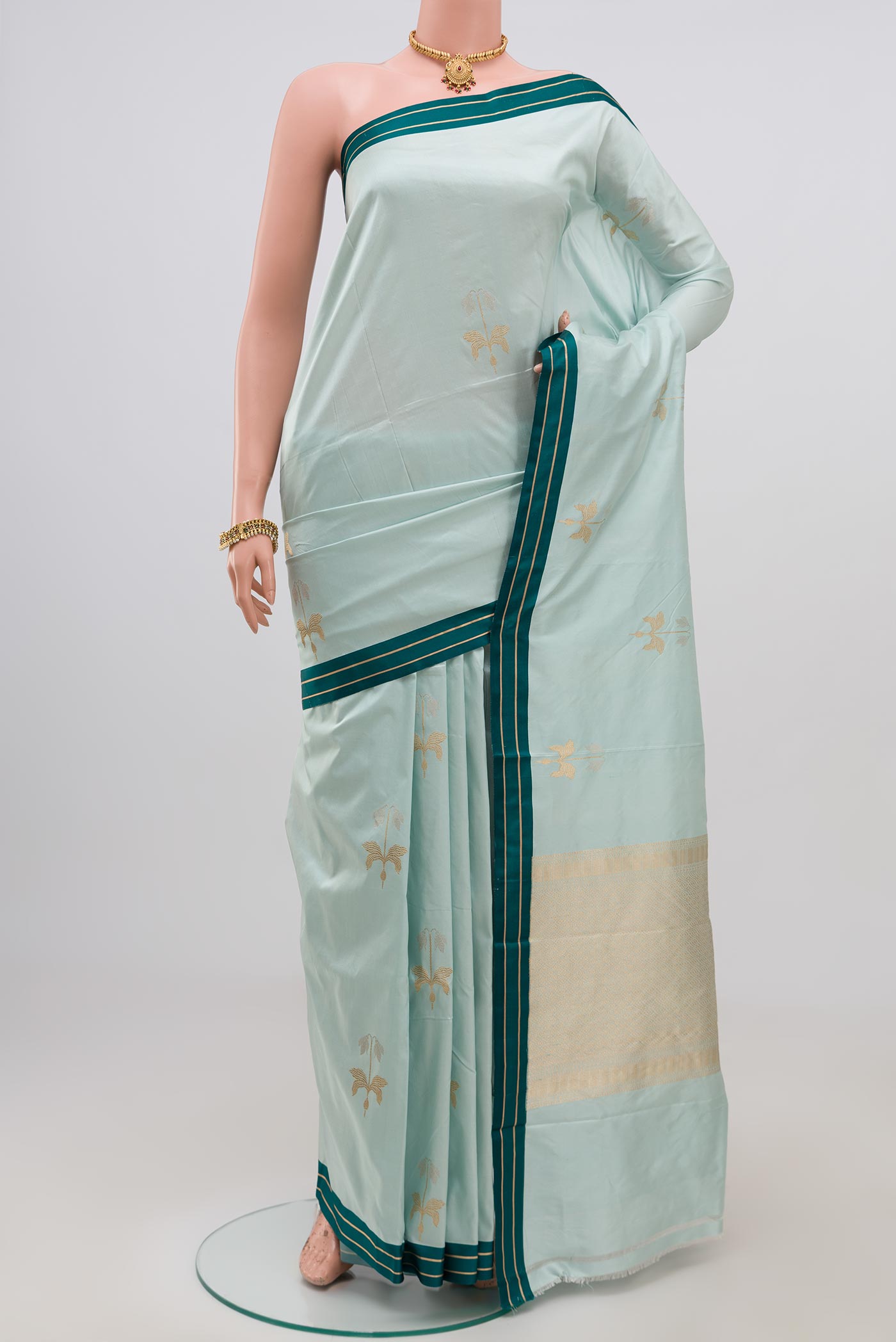 Blue Banarasi Katan Silk Saree with Zari Butta on the body and Thin Zari Line.  displayed on a mannequin