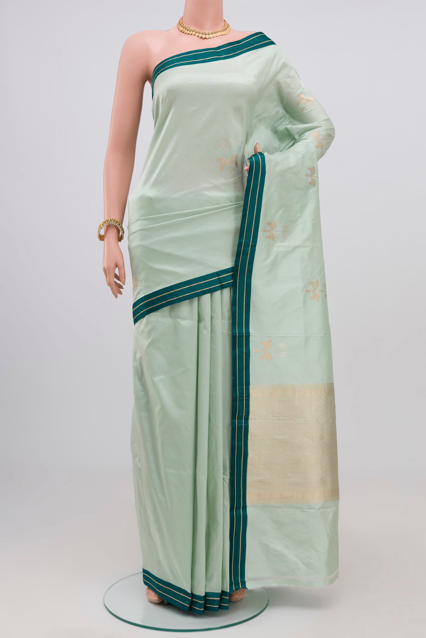 Light Blue Banarasi Katan Silk Saree with Zari Butta on the body and Plain Border.  displayed on a mannequin