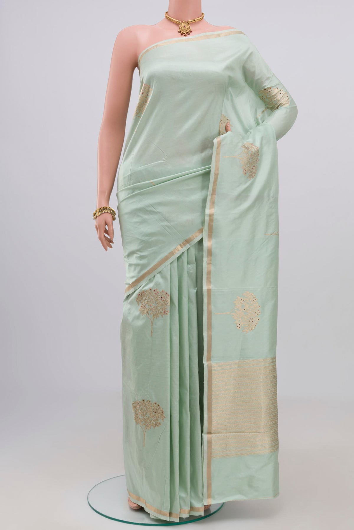 Light Green Banarasi Katan Silk Saree with Zari Butta on the body and Thin Zari Line.  displayed on a mannequin