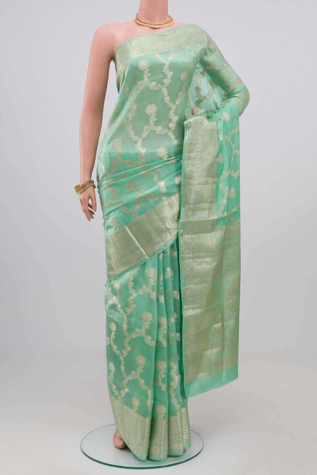 Light Green Raw Silk Saree with Zari Butta on the body and Zari Border.  displayed on a mannequin
