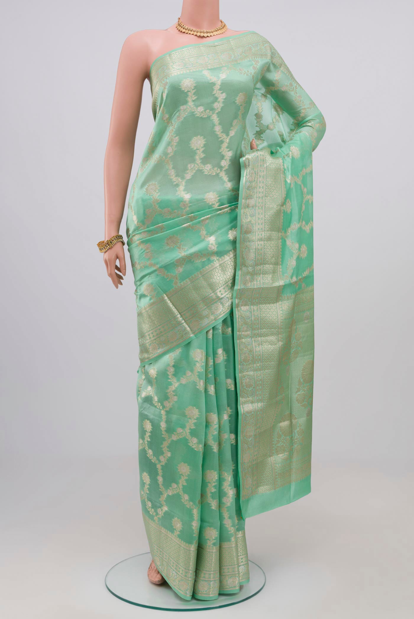 Light Green Raw Silk Saree with Zari Butta on the body and Zari Border.  displayed on a mannequin