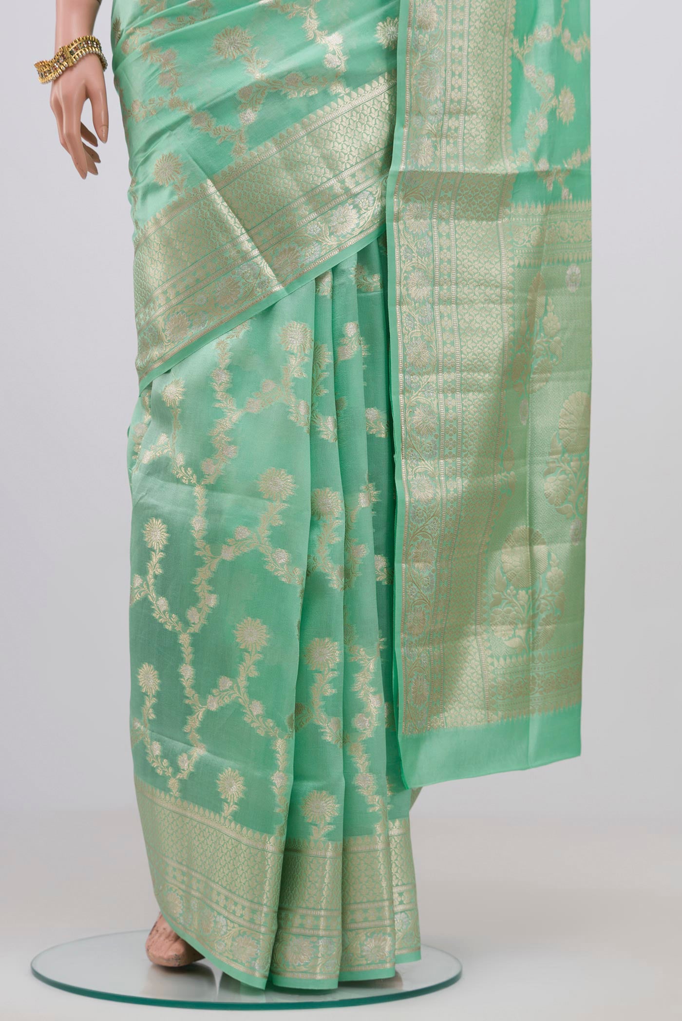 Pleats and pallu of Light Green Raw Silk Saree with Zari Butta on the body and Zari Border. 