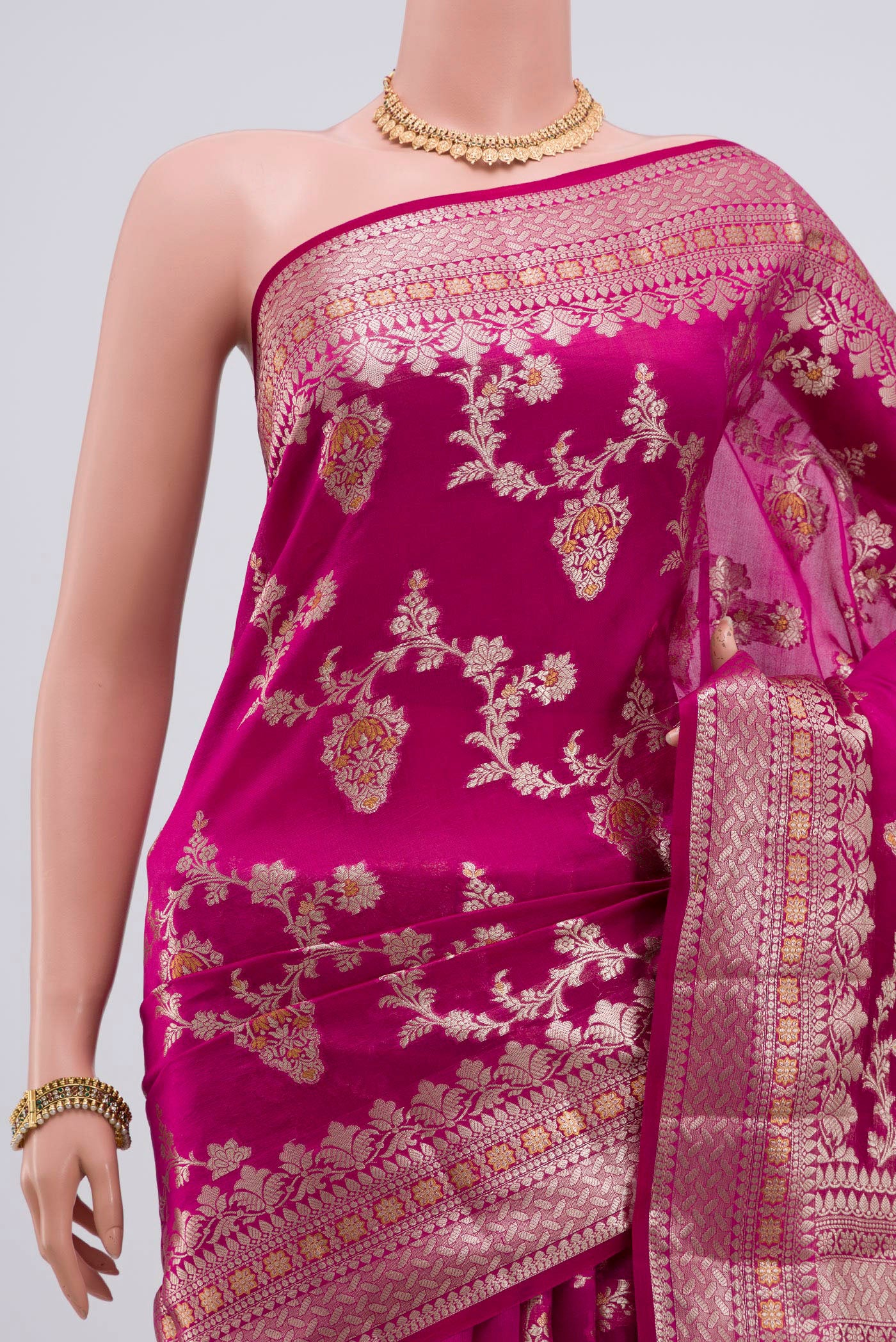 Border image of Rani Pink Raw Silk Saree with Zari Butta on the body and Zari Border. 