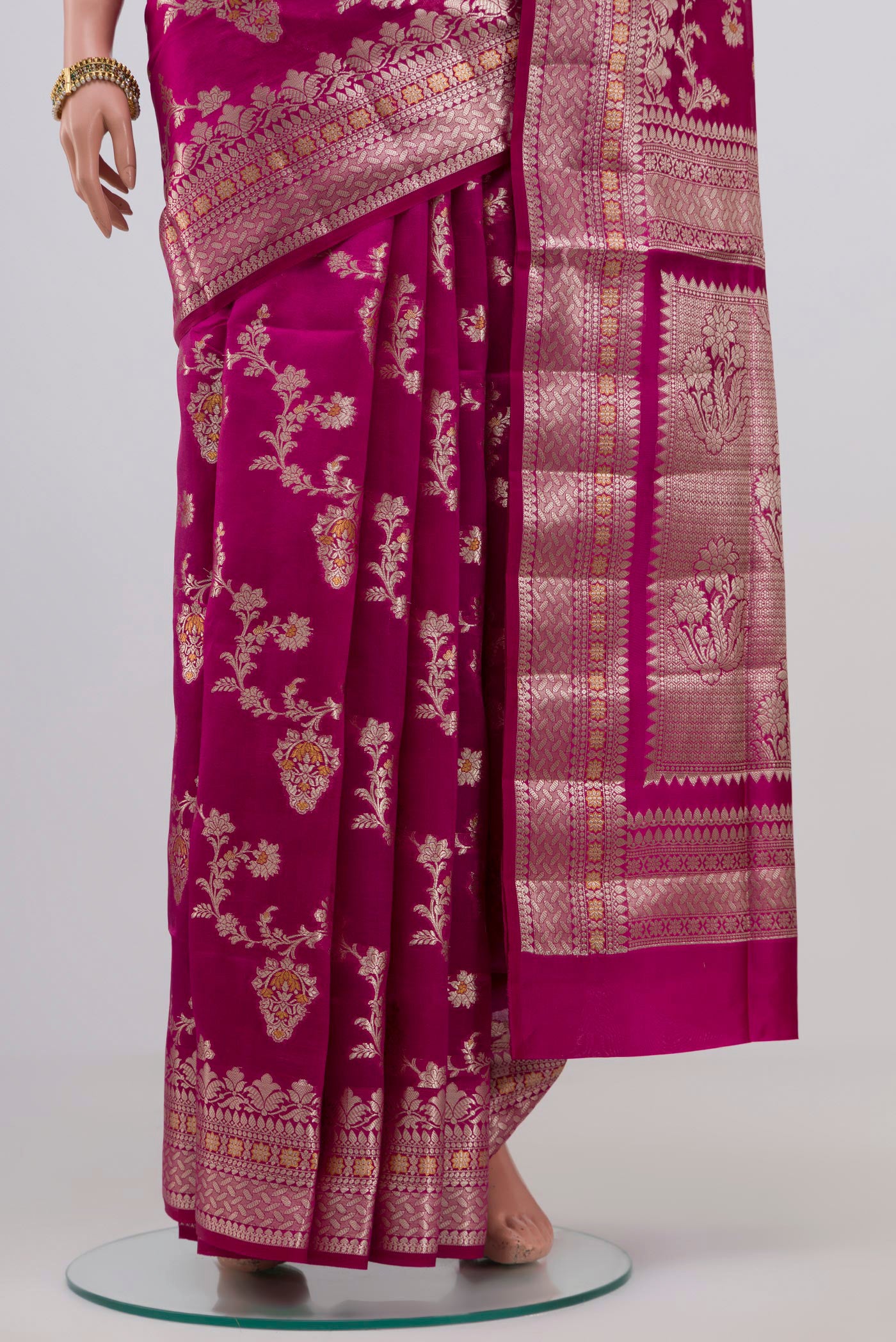 Pleats and pallu of Rani Pink Raw Silk Saree with Zari Butta on the body and Zari Border. 