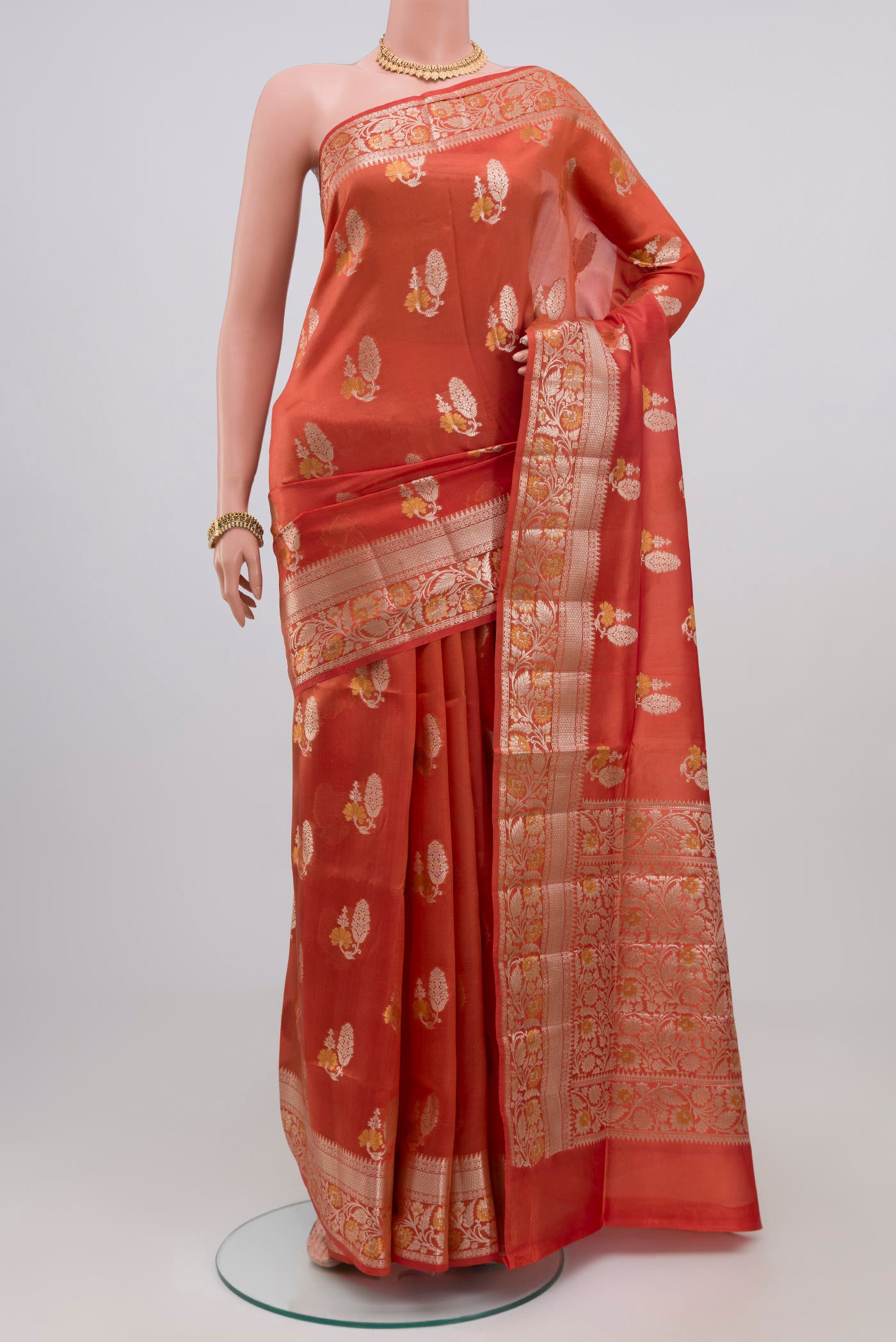 Peach Raw Silk Saree with Zari Butta on the body and Zari Border.  displayed on a mannequin