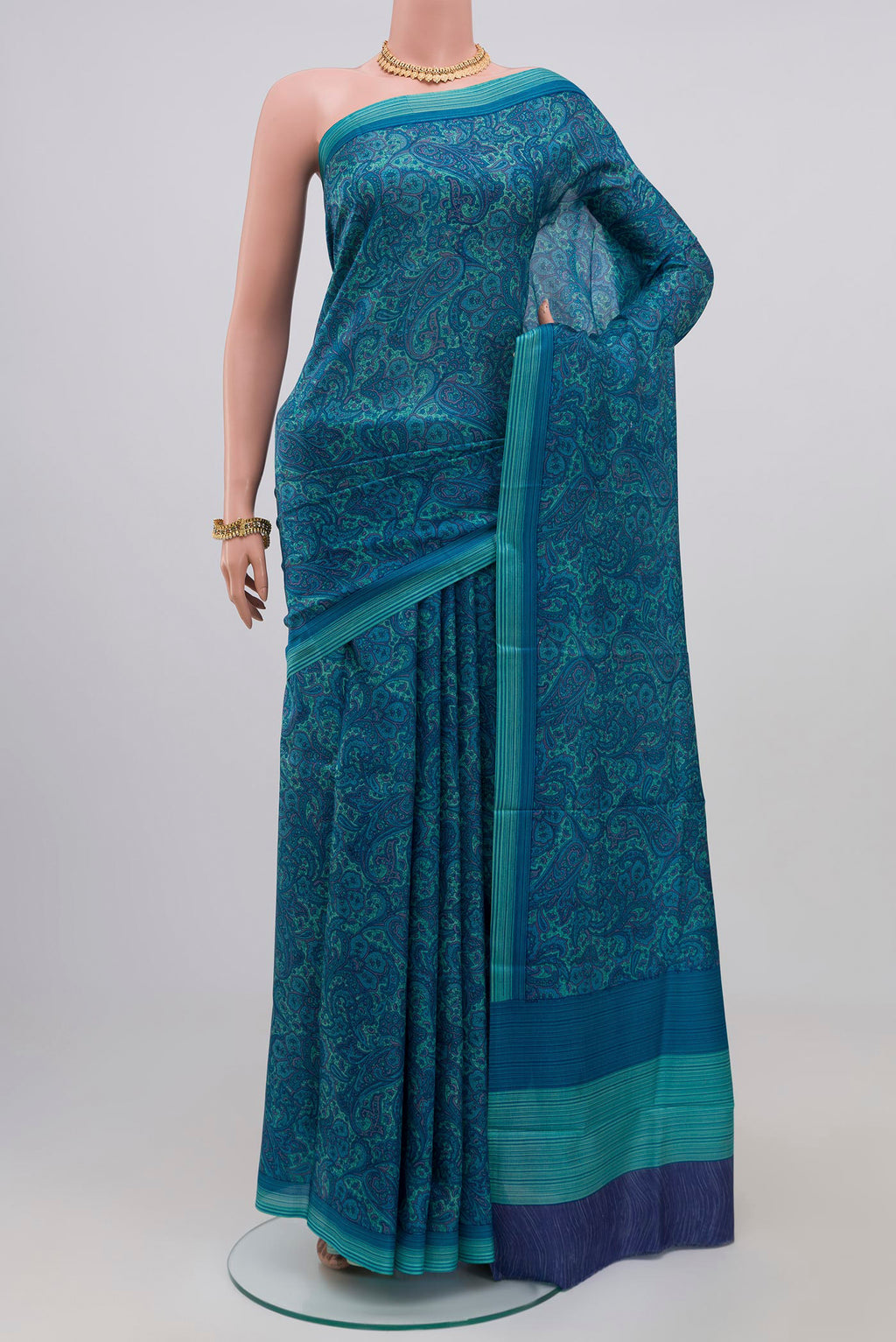 Blue Printed Silk Saree with Printed design on the body and Plain Border.  displayed on a mannequin