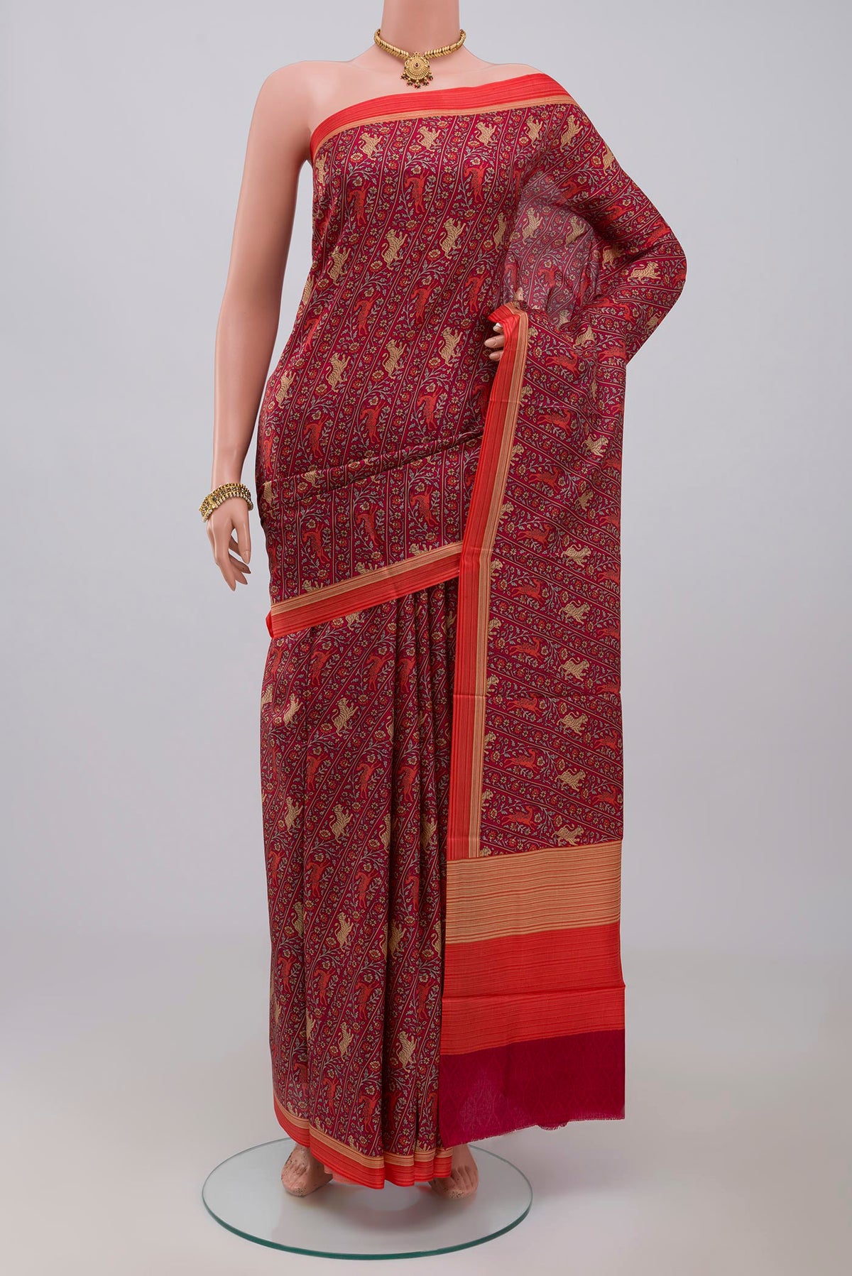 Red Printed Silk Saree with Printed design on the body and Plain Border.  displayed on a mannequin
