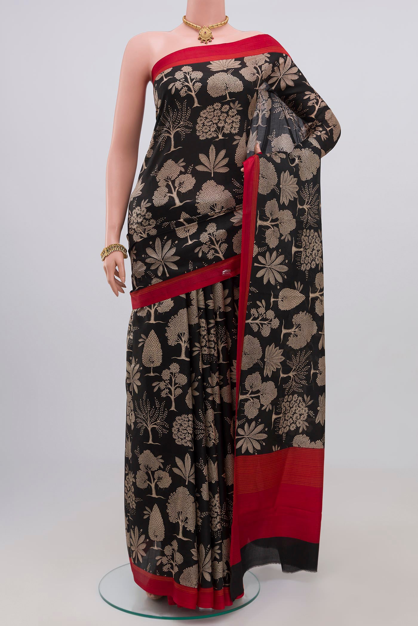 Black Printed Silk Saree with Printed design on the body and Plain Border.  displayed on a mannequin