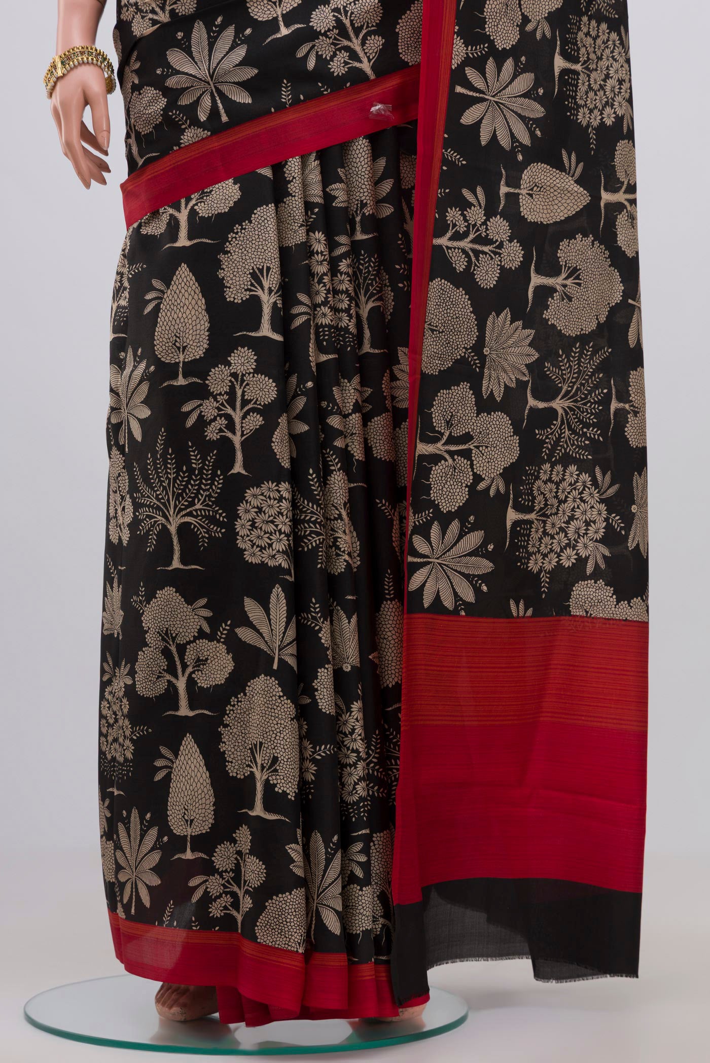 Pleats and pallu of Black Printed Silk Saree with Printed design on the body and Plain Border. 