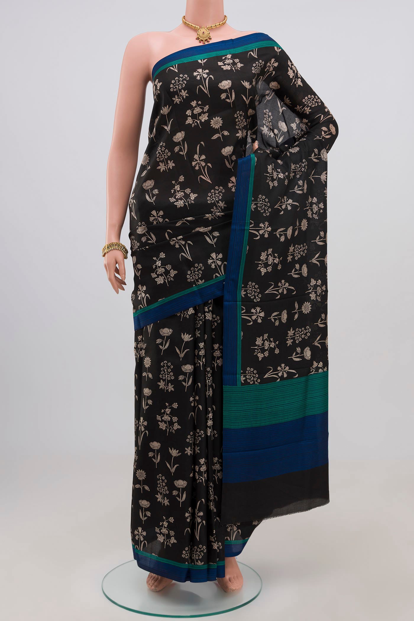 Black Printed Silk Saree with Printed design on the body and Plain Border.  displayed on a mannequin