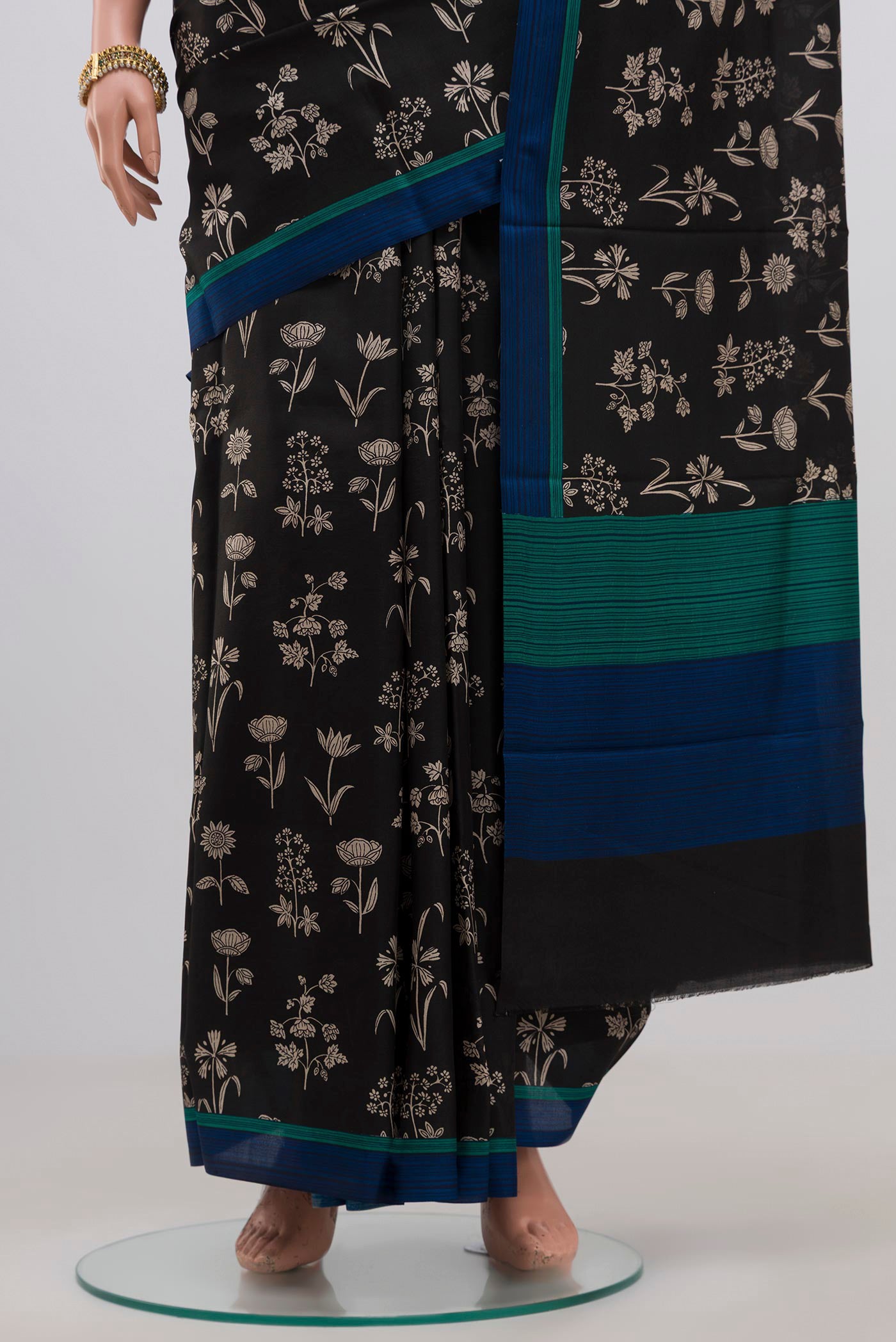 Pleats and pallu of Black Printed Silk Saree with Printed design on the body and Plain Border. 