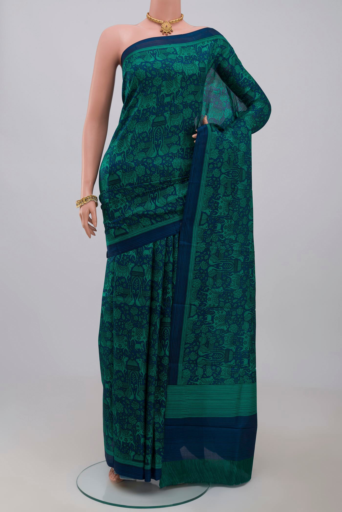 Blue Printed Silk Saree with Printed design on the body and Plain Border.  displayed on a mannequin