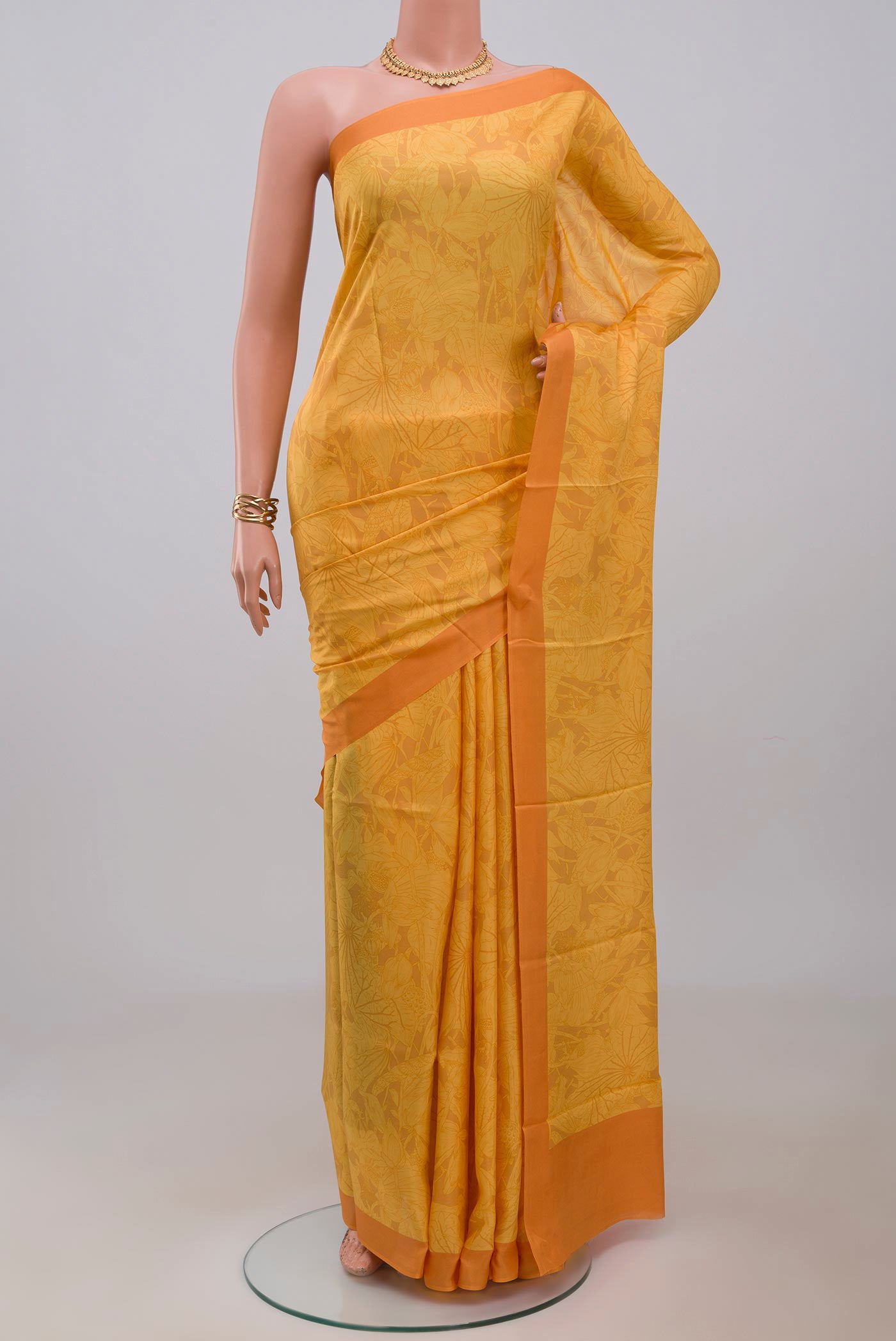 Yellow Printed Silk Saree with Printed design on the body and Plain Border.  displayed on a mannequin