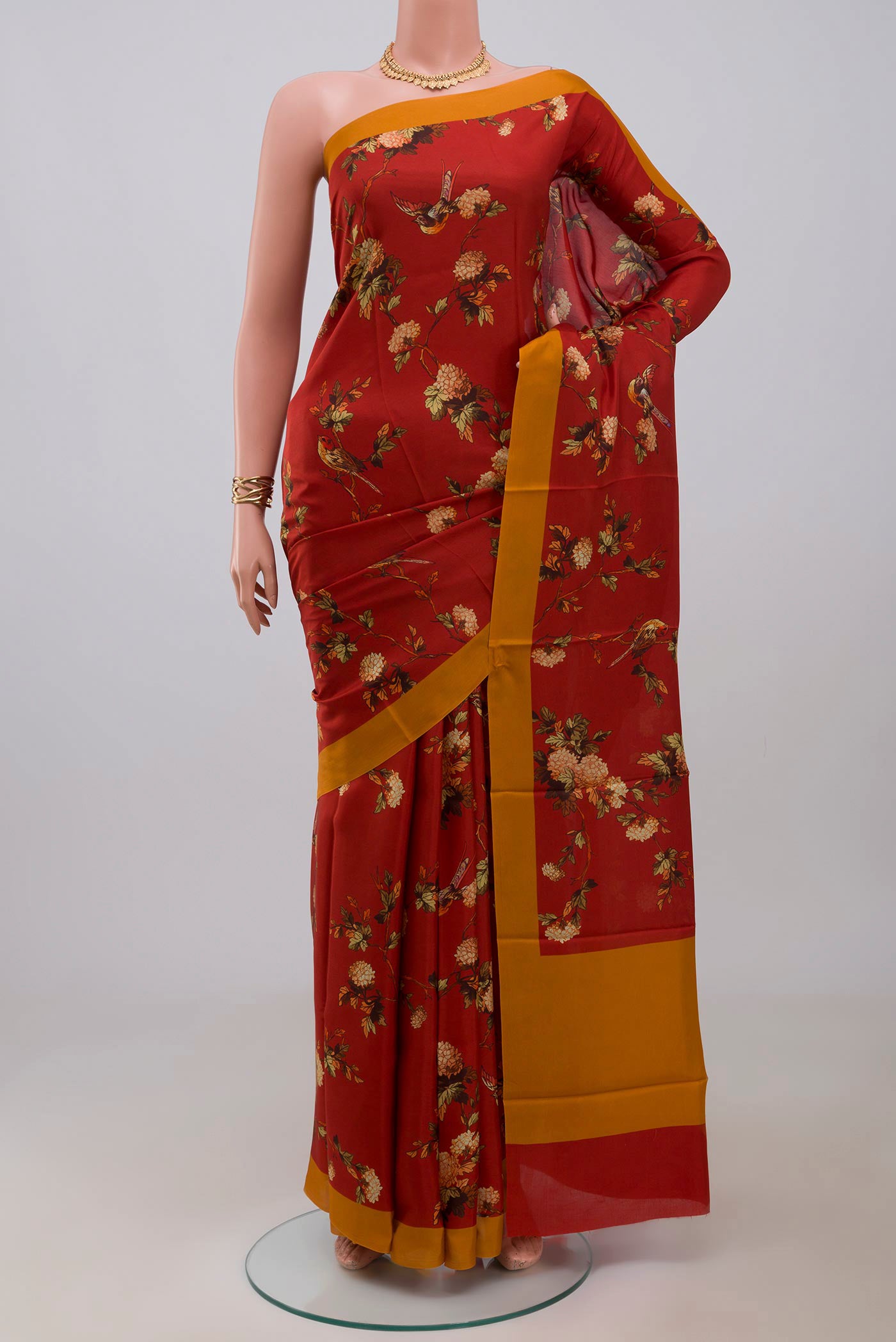 Red Printed Silk Saree with Printed design on the body and Plain Border.  displayed on a mannequin