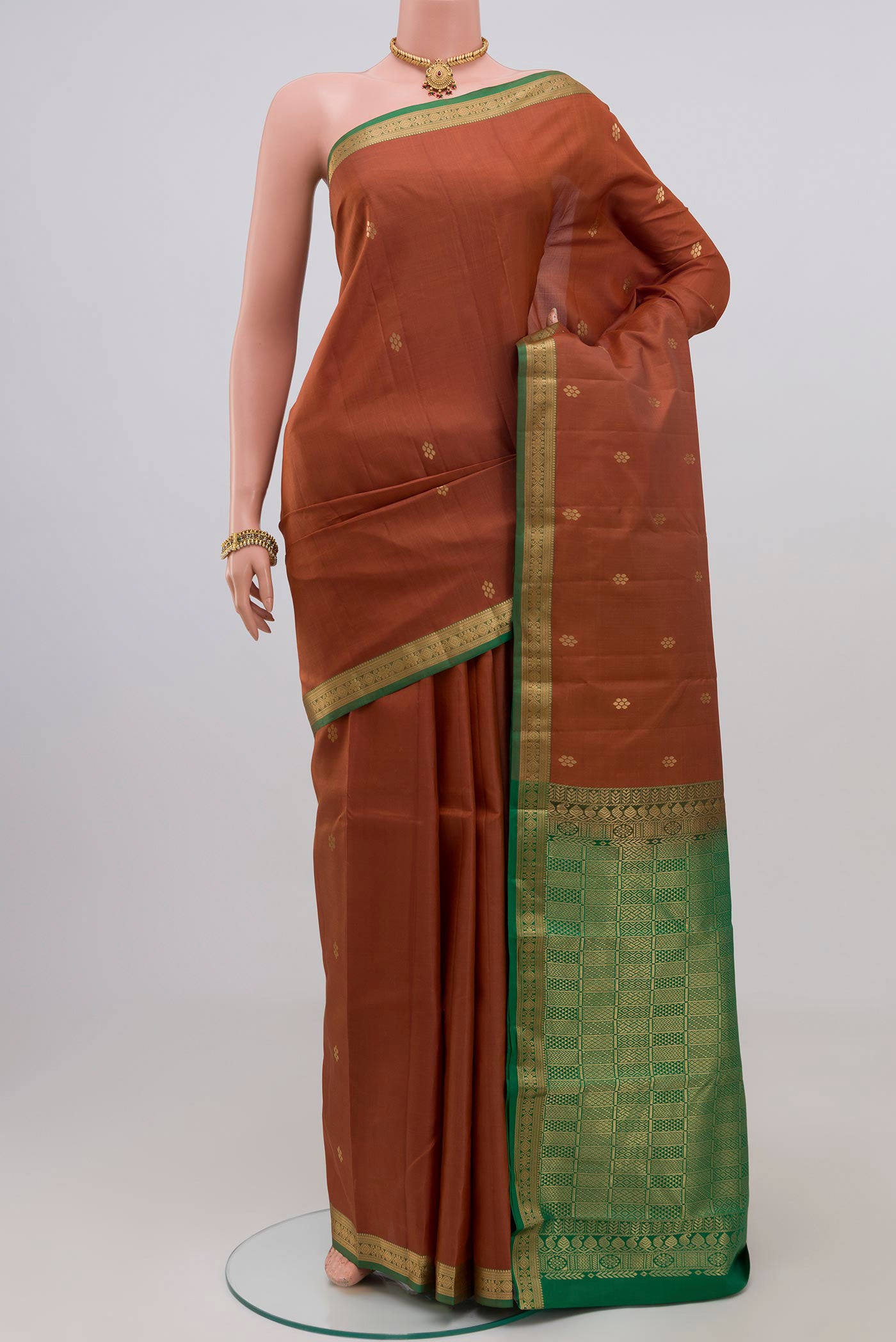 Brown Kanjivaram Silk Saree with Zari Butta on the body and Zari Border.  displayed on a mannequin