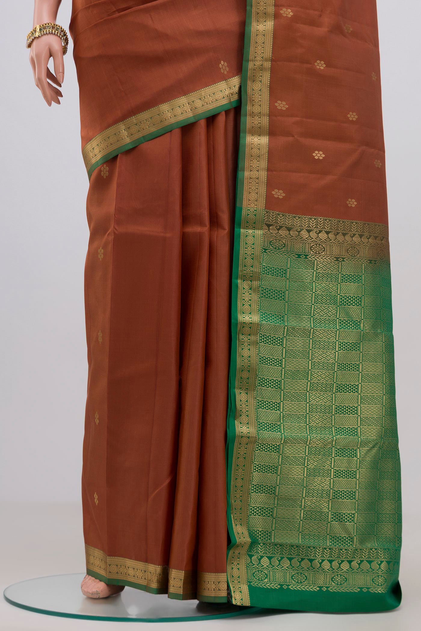 Pleats and pallu of Brown Kanjivaram Silk Saree with Zari Butta on the body and Zari Border. 