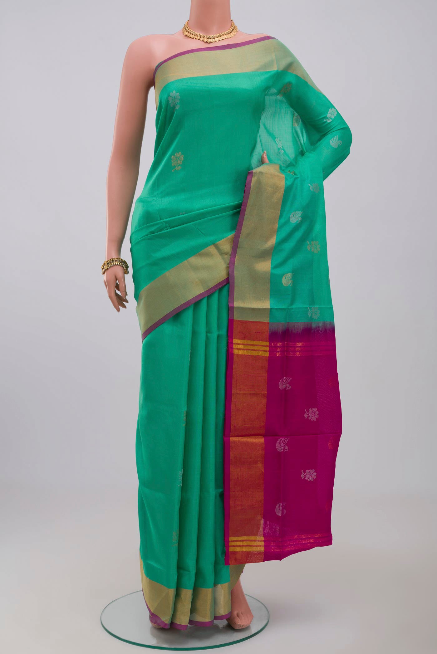 Green Uppada Silk Saree with Zari Butta on the body and Zari Border.  displayed on a mannequin
