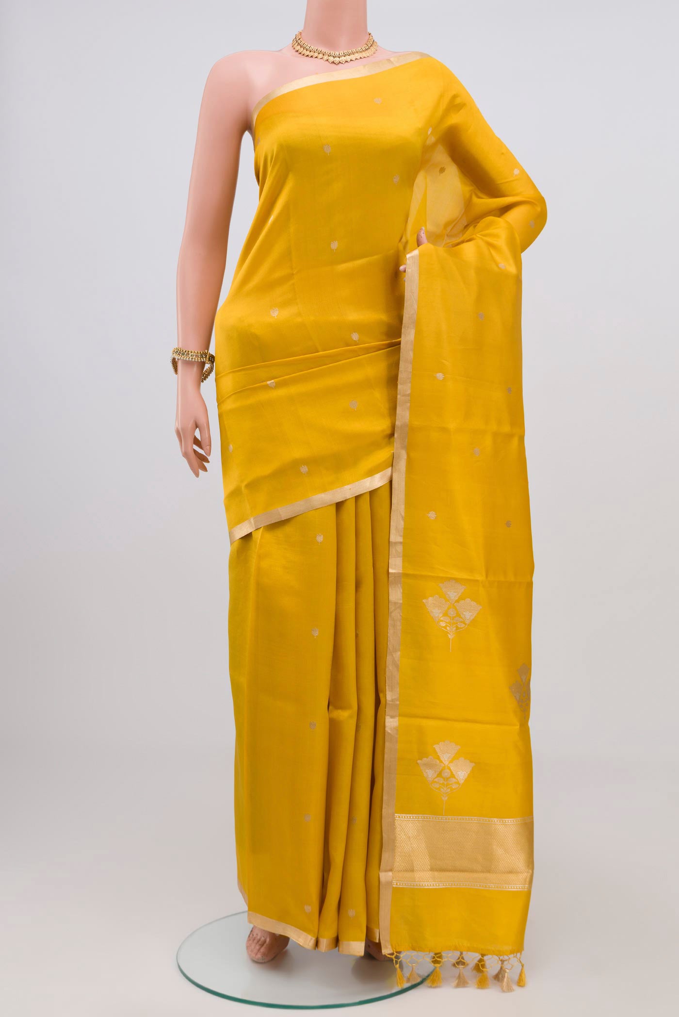 Yellow Banarasi Katan Silk Saree with Zari Butta on the body and Zari Border.  displayed on a mannequin