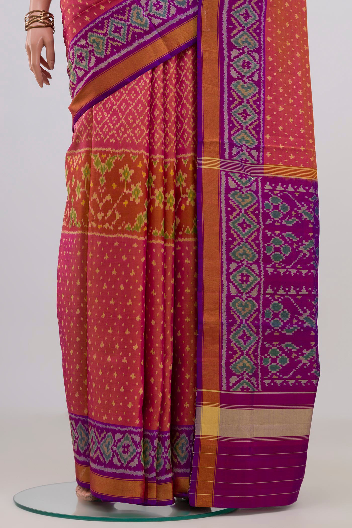 Pleats and pallu of Pinkish Yellow Rajkot Patola Silk Saree with Ikat design on the body and Ikat Border. 