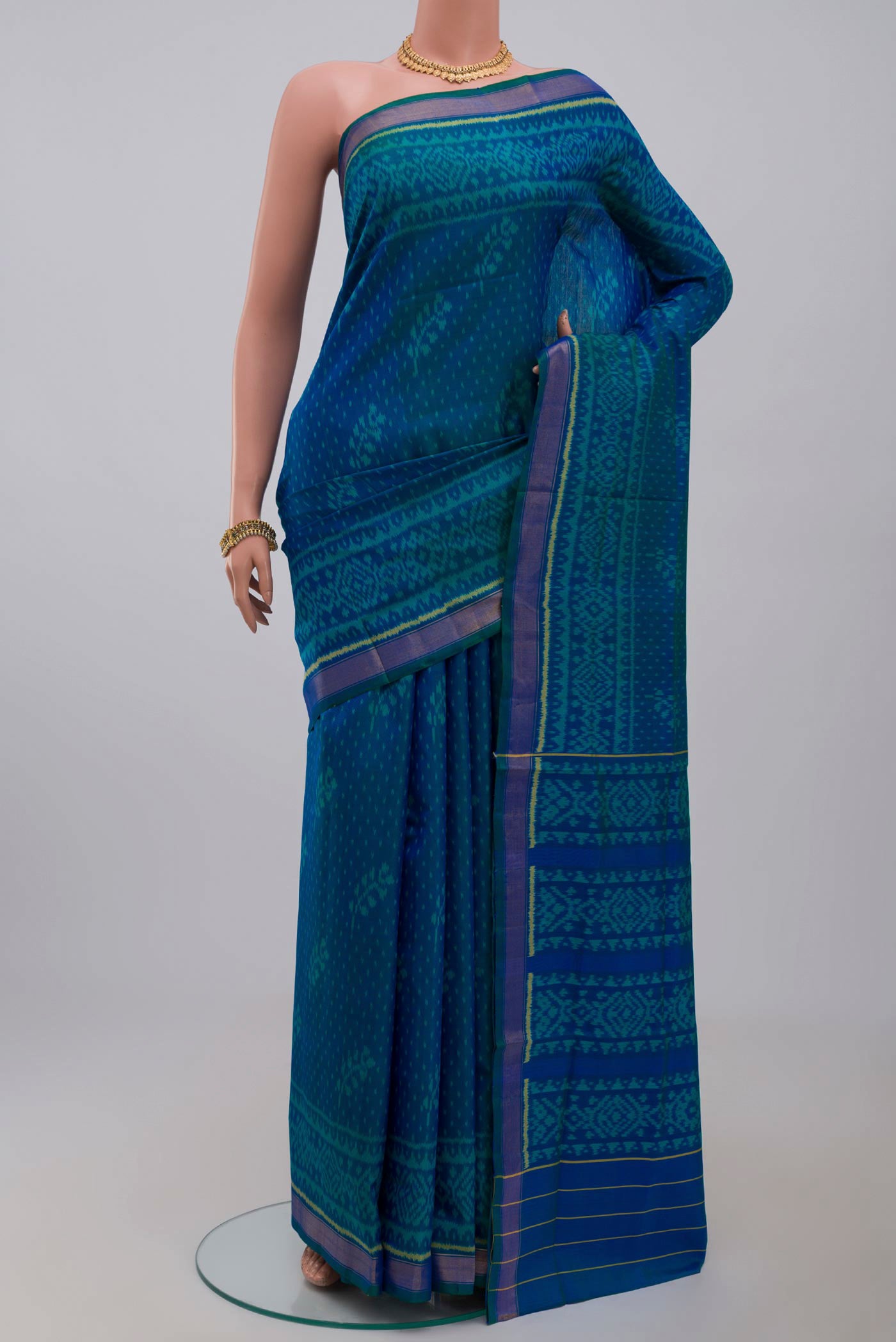 Blue Rajkot Patola Silk Saree with Ikat Print on the body and Zari Border.  displayed on a mannequin