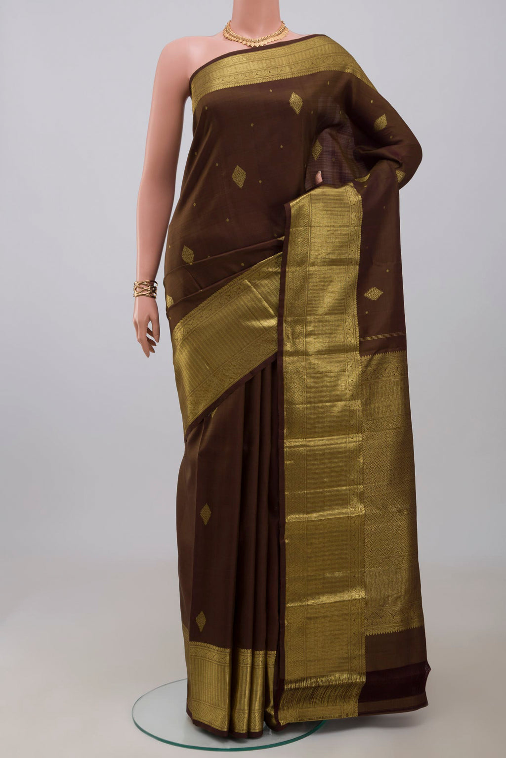 Mehandi Green Kanjivaram Silk Saree with Zari Butta on the body and Zari Border.  displayed on a mannequin
