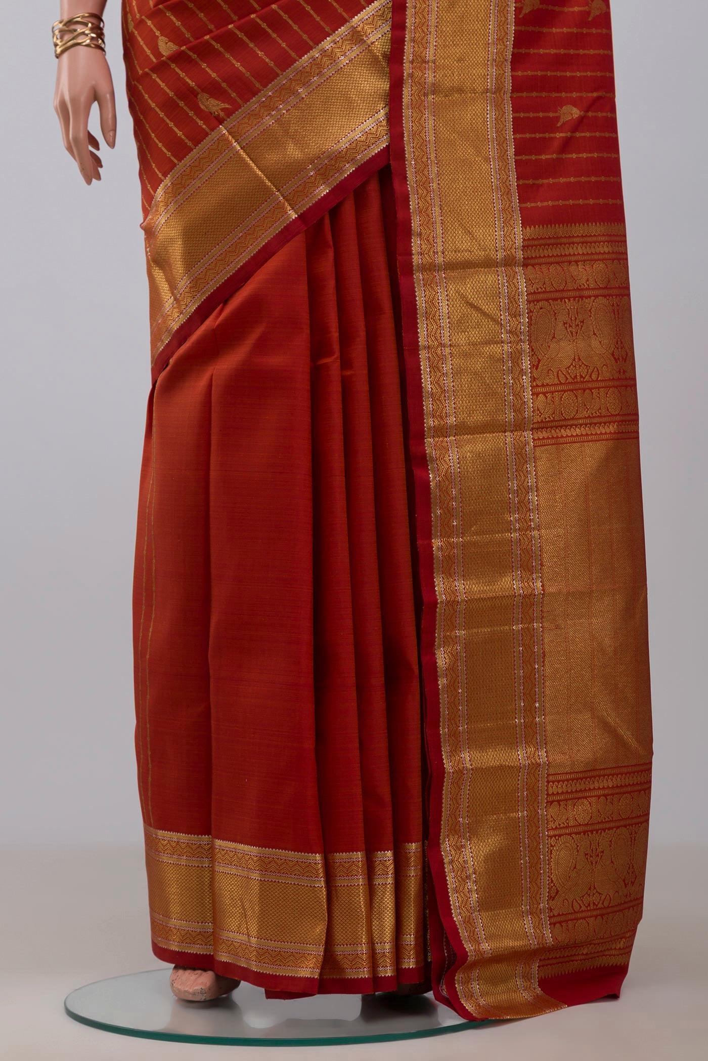 Pleats and pallu of Rust Kanchipuram Silk Saree with Stripes on the body and Zari Border. 