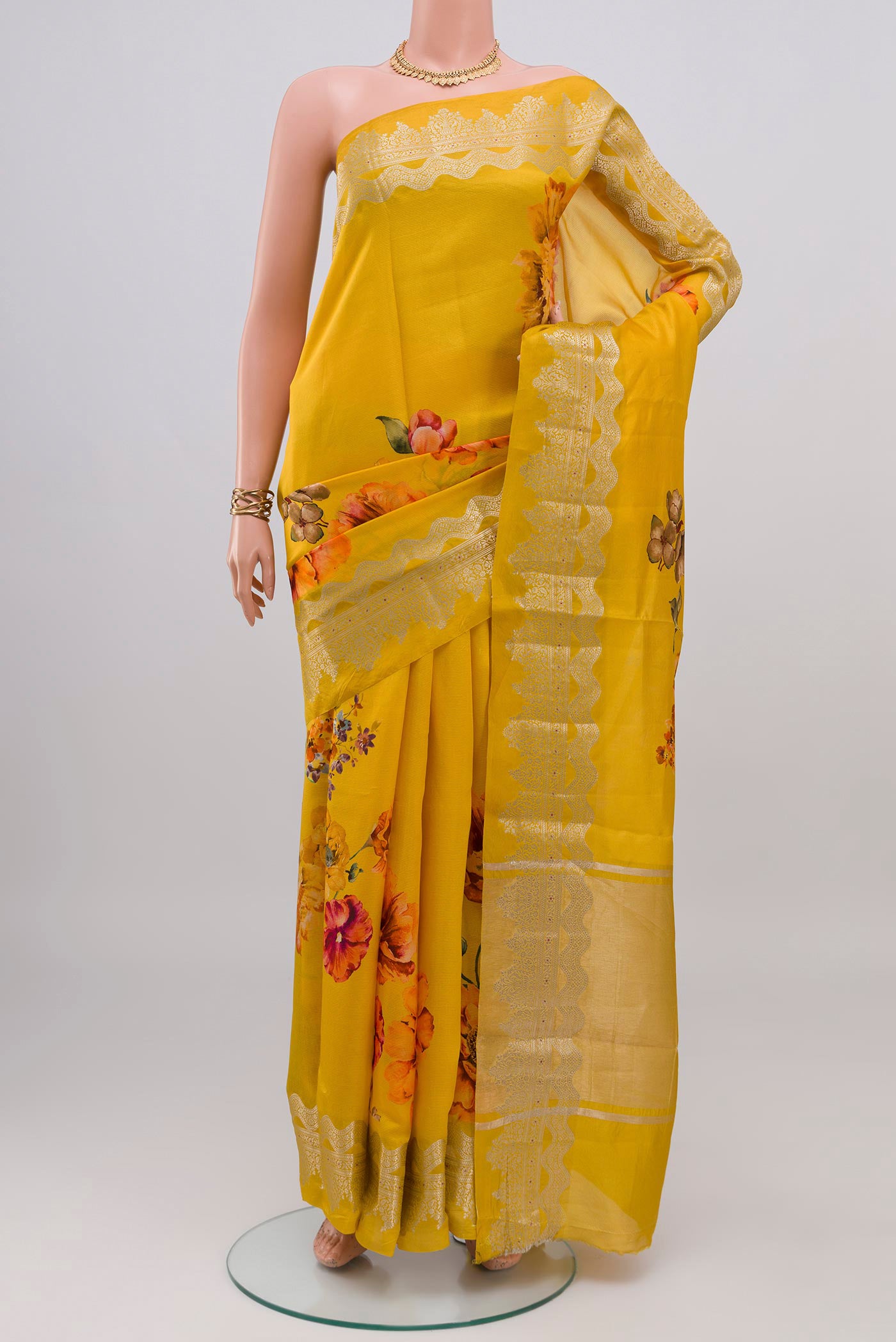 Yellow Raw Silk Saree with Floral Print on the body and Fancy Border.  displayed on a mannequin