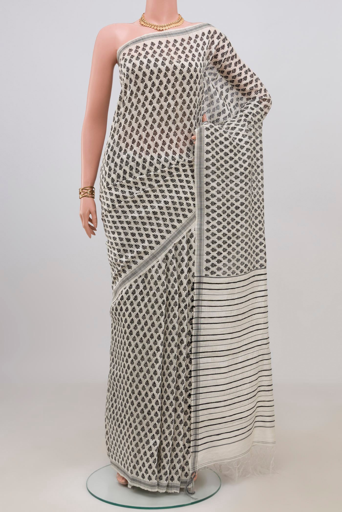 White Tussar Silk Saree with Printed design on the body and Plain Border.  displayed on a mannequin