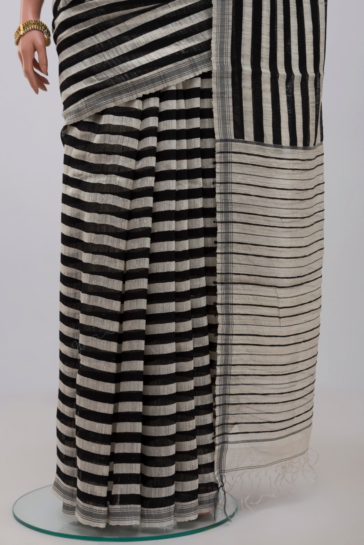 Pleats and pallu of Black Jute Silk Saree with Fancy on the body and Without Border. 