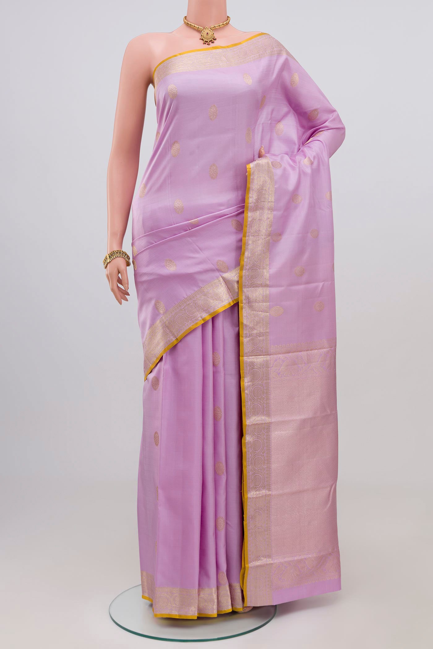 Lavender Kanjivaram Silk Saree with Zari Butta on the body and Zari Border.  displayed on a mannequin