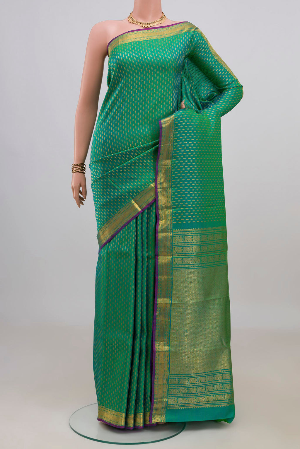 Pure Silk Green Kanchipuram Saree with Zari Butta on the body and Zari Border.  displayed on a mannequin