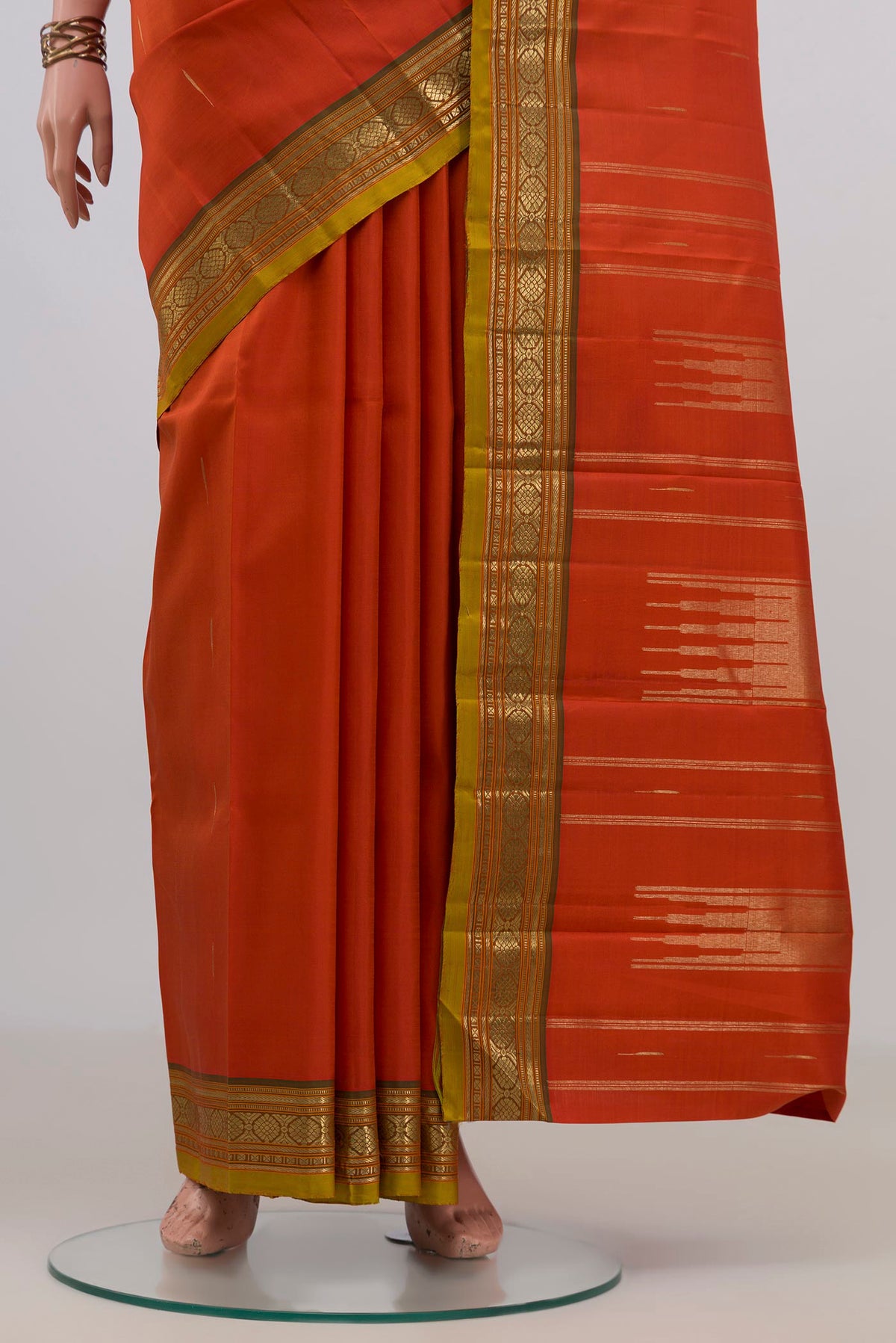 Pleats and pallu of Pure Silk Orange Kanjivaram Saree with Zari Butta on the body and Zari Border. 