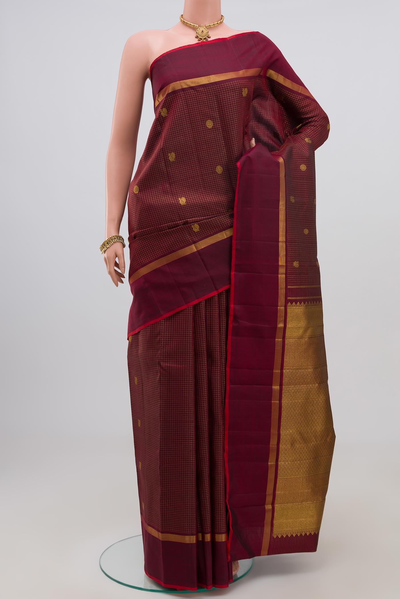 Maroon Kanjivaram Saree with Checked design on the body and Thin Zari Line.  displayed on a mannequin