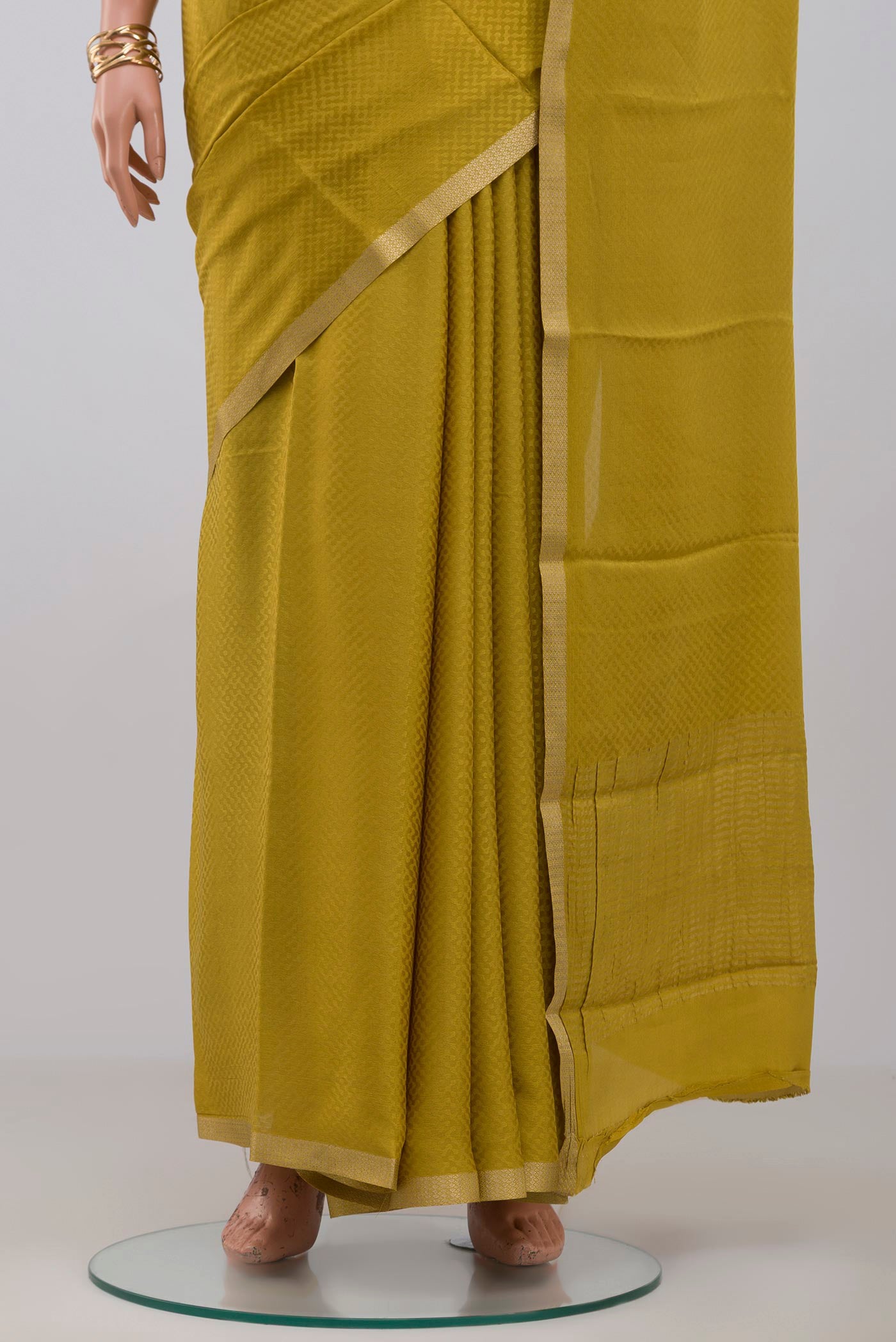 Pleats and pallu of Yellow Crepe Saree with Fancy on the body and Zari Border. 
