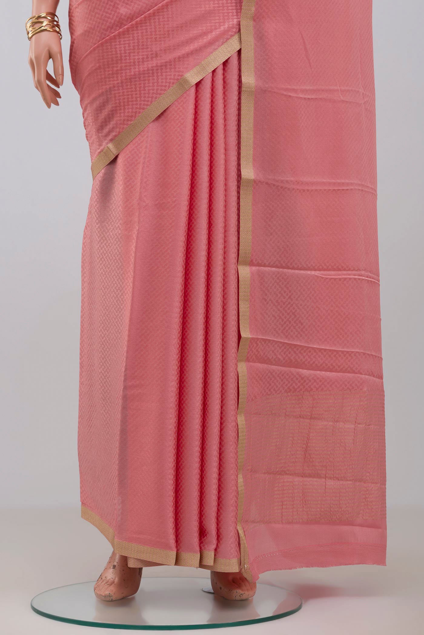 Pleats and pallu of Pink Crepe Saree with Fancy on the body and Zari Border. 