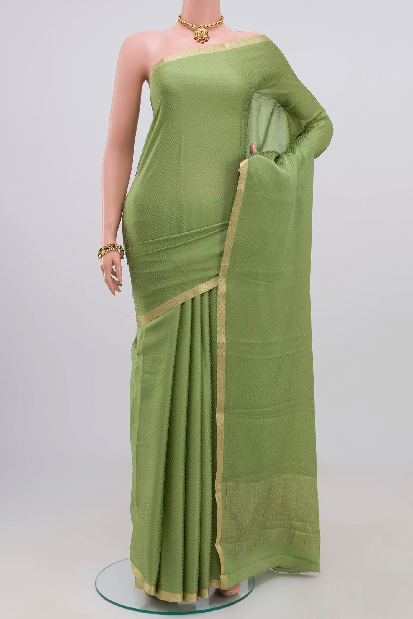 Green Crepe Saree with Jacquard design on the body and Zari Border.  displayed on a mannequin
