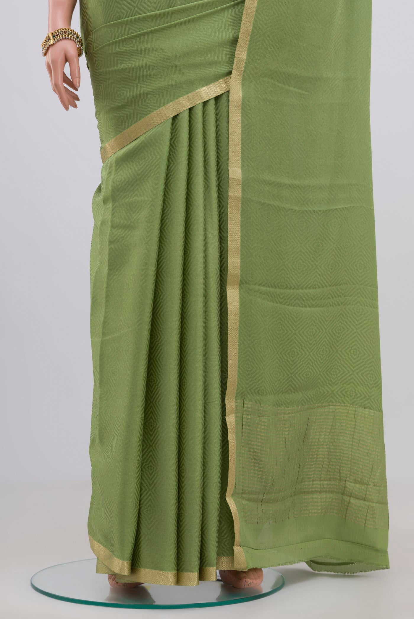 Pleats and pallu of Green Crepe Saree with Jacquard design on the body and Zari Border. 