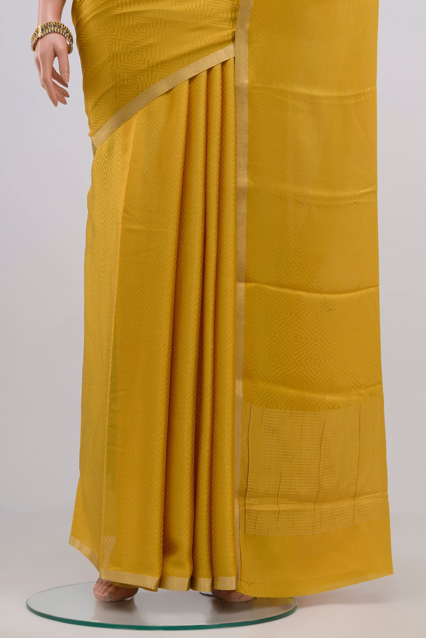 Pleats and pallu of Yellow Crepe Saree with Jacquard design on the body and Thin Zari Line. 