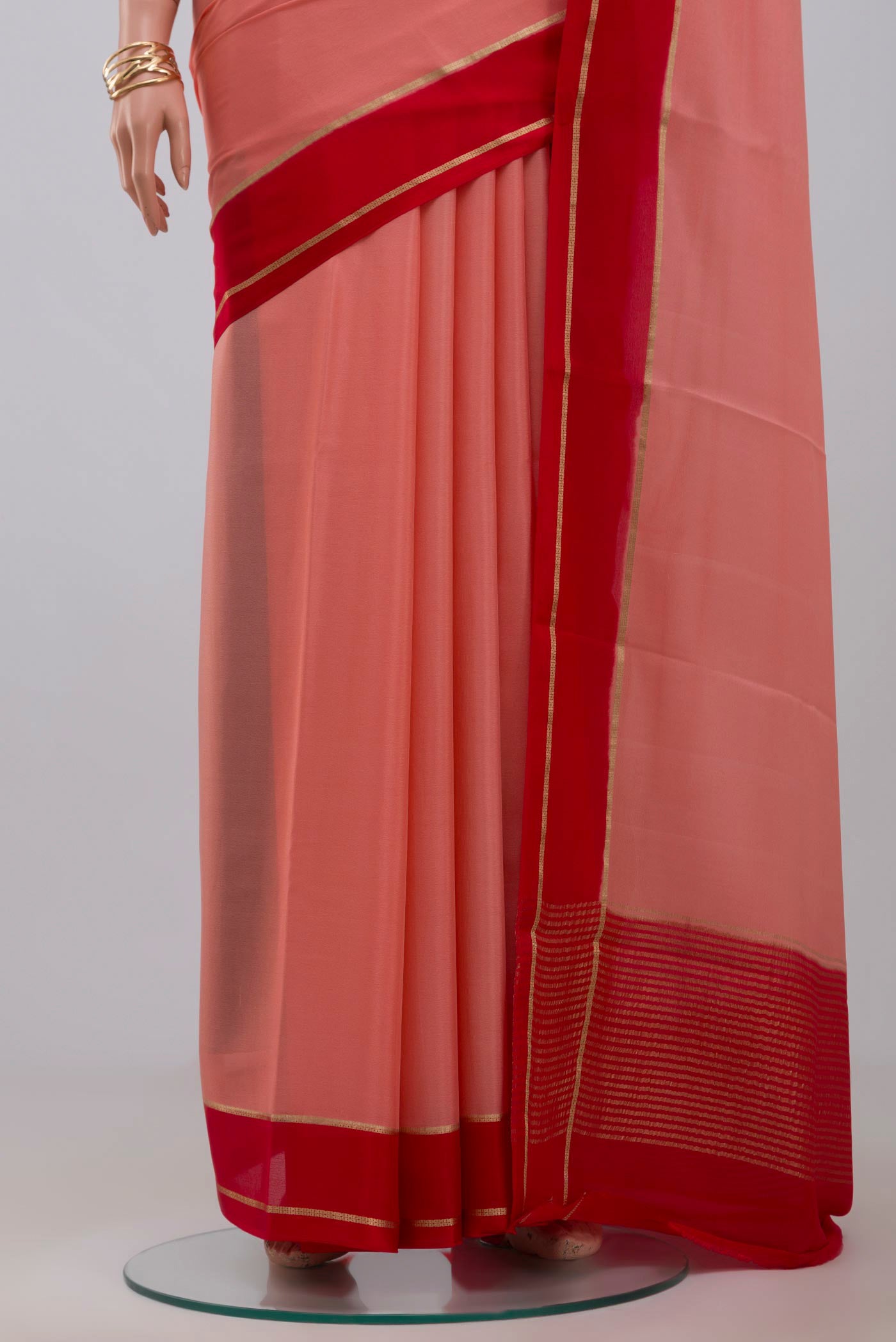 Pleats and pallu of Peach Crepe Saree with Plain Body and Thin Zari Line. 