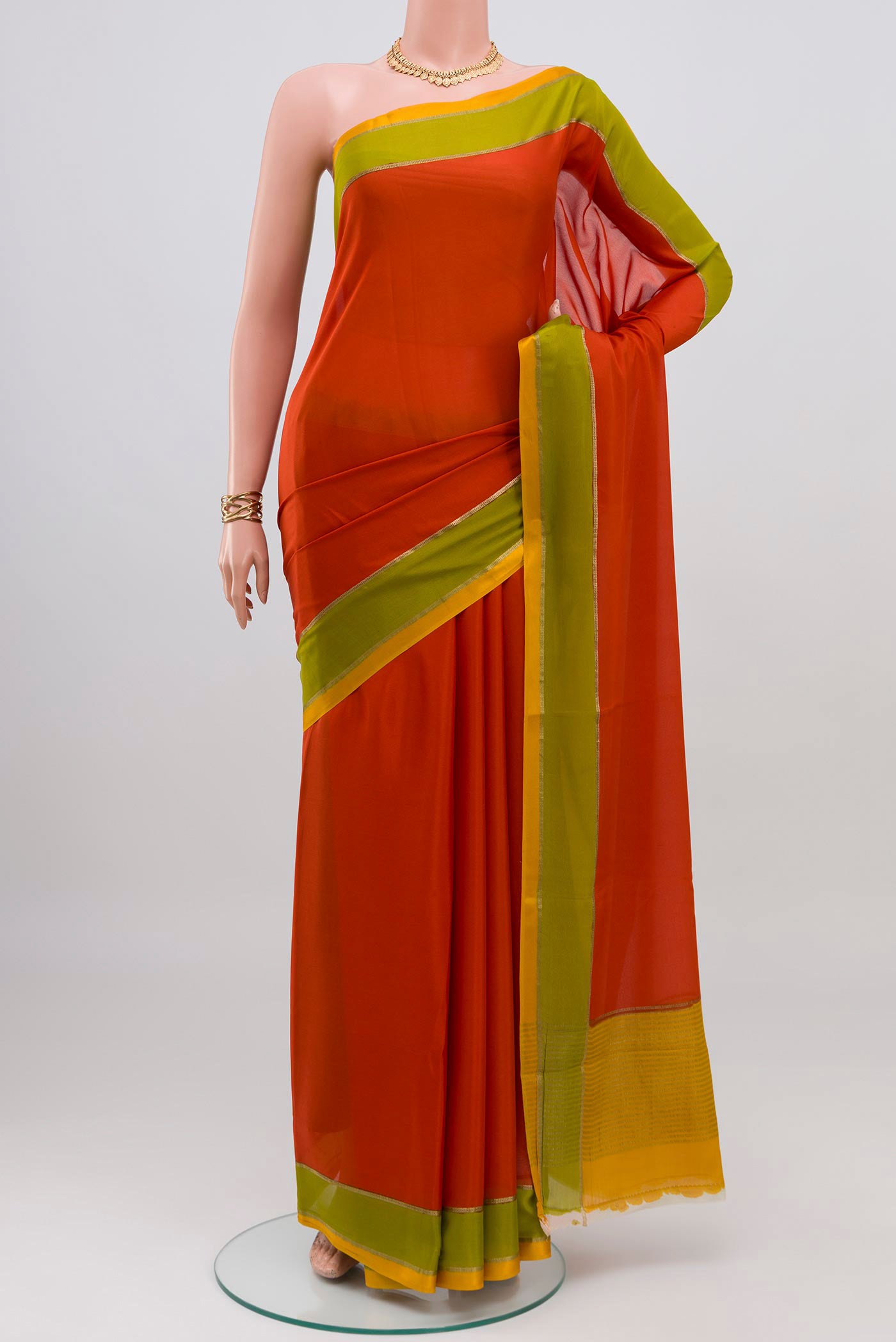 Orange Mysore Crepe Saree with Plain Body and Plain Border.  displayed on a mannequin