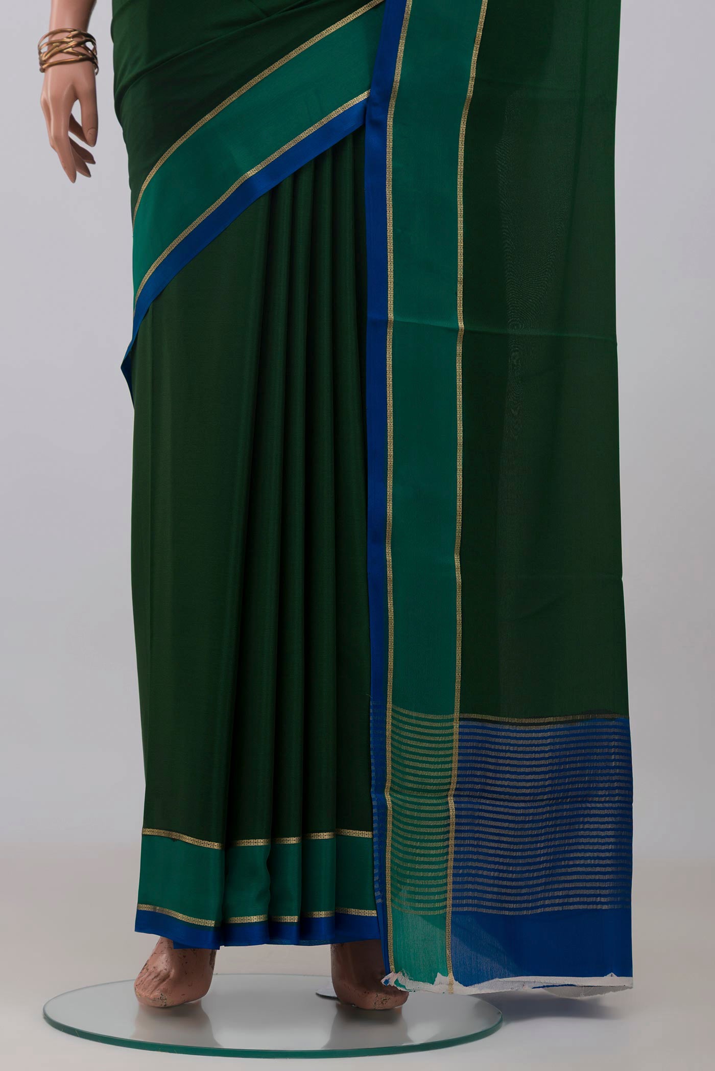 Pleats and pallu of Bottle Green Mysore Crepe Saree with Plain Body and Thin Zari Line. 