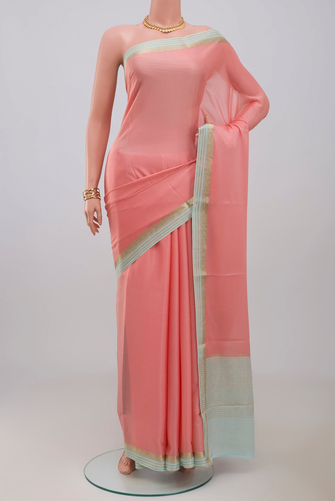 Pink Crepe Saree with Plain Body and Fancy Border.  displayed on a mannequin