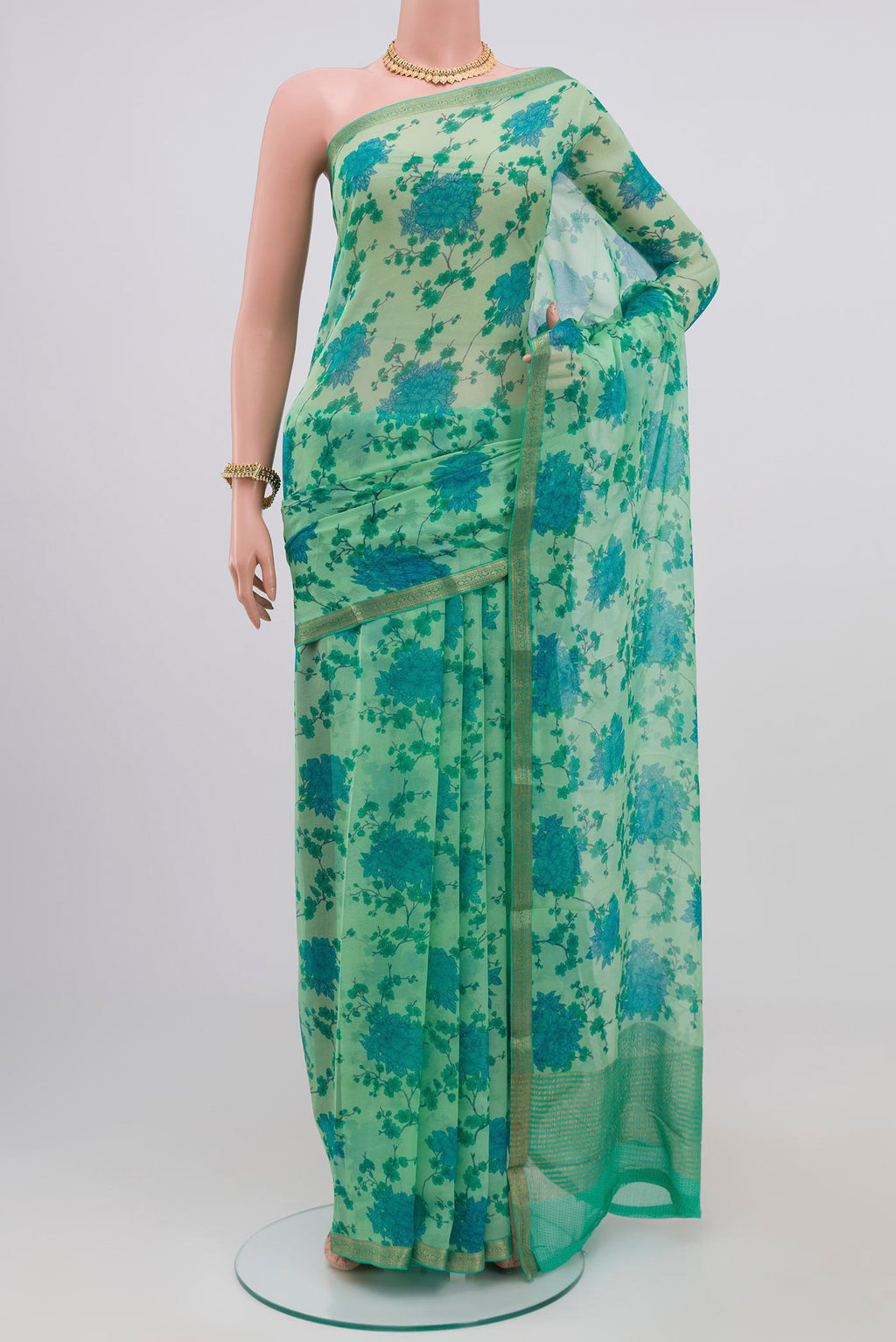 Pista Green Chiffon Saree with Printed design on the body and Zari Border.  displayed on a mannequin