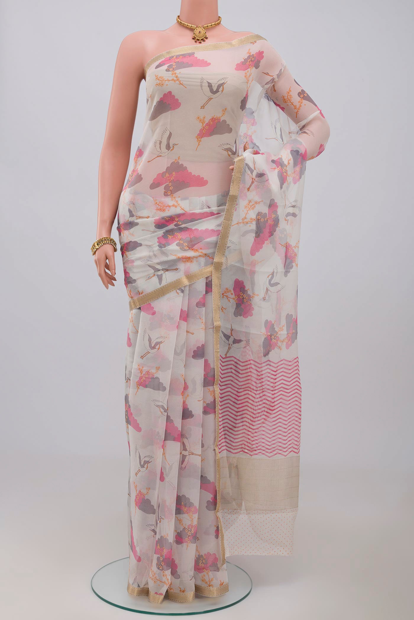 White Chiffon Saree with Printed design on the body and Thin Zari Line.  displayed on a mannequin