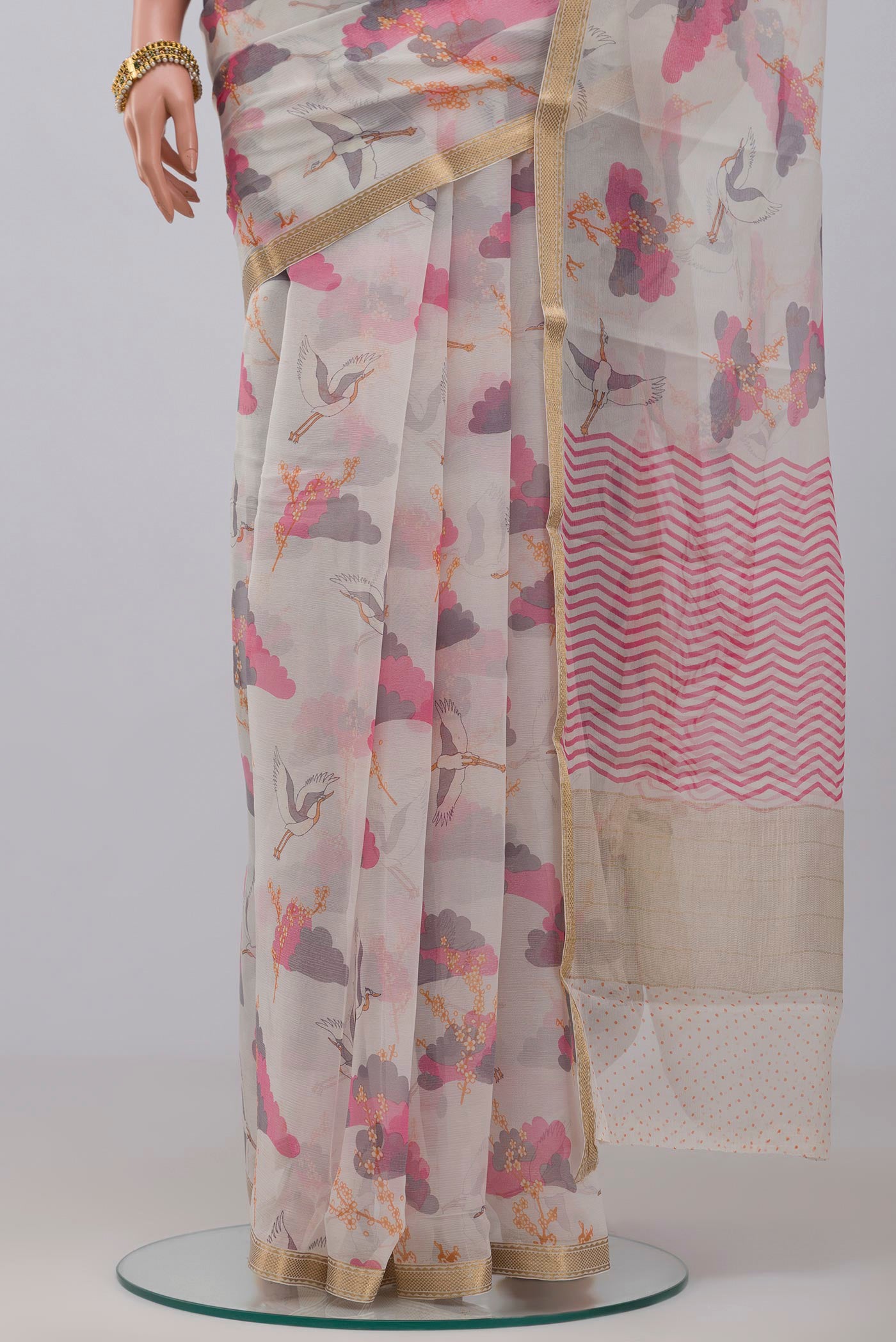 Pleats and pallu of White Chiffon Saree with Printed design on the body and Thin Zari Line. 